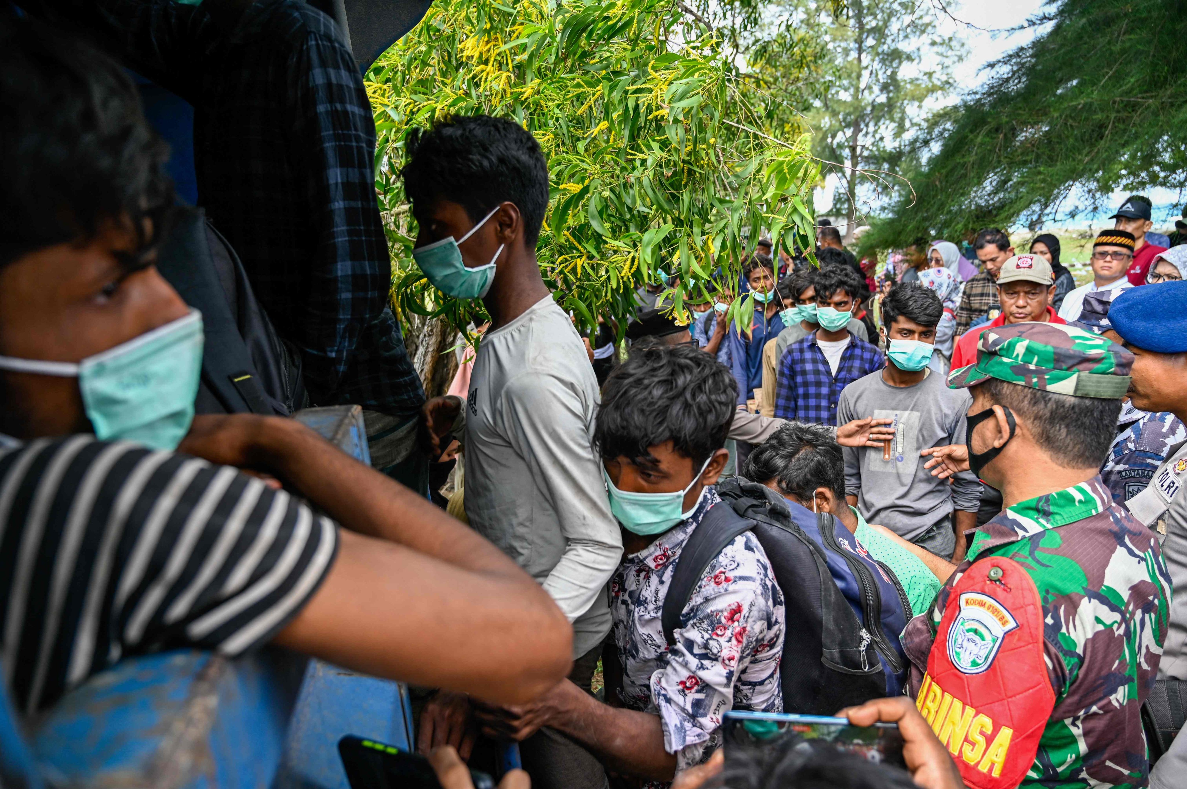 A group of Rohingya refugees board a truck to be transferred to a temporary shelter following their arrival by boat in Krueng Raya, Indonesia’s Aceh province on December 25, 2022. Photo: AFP