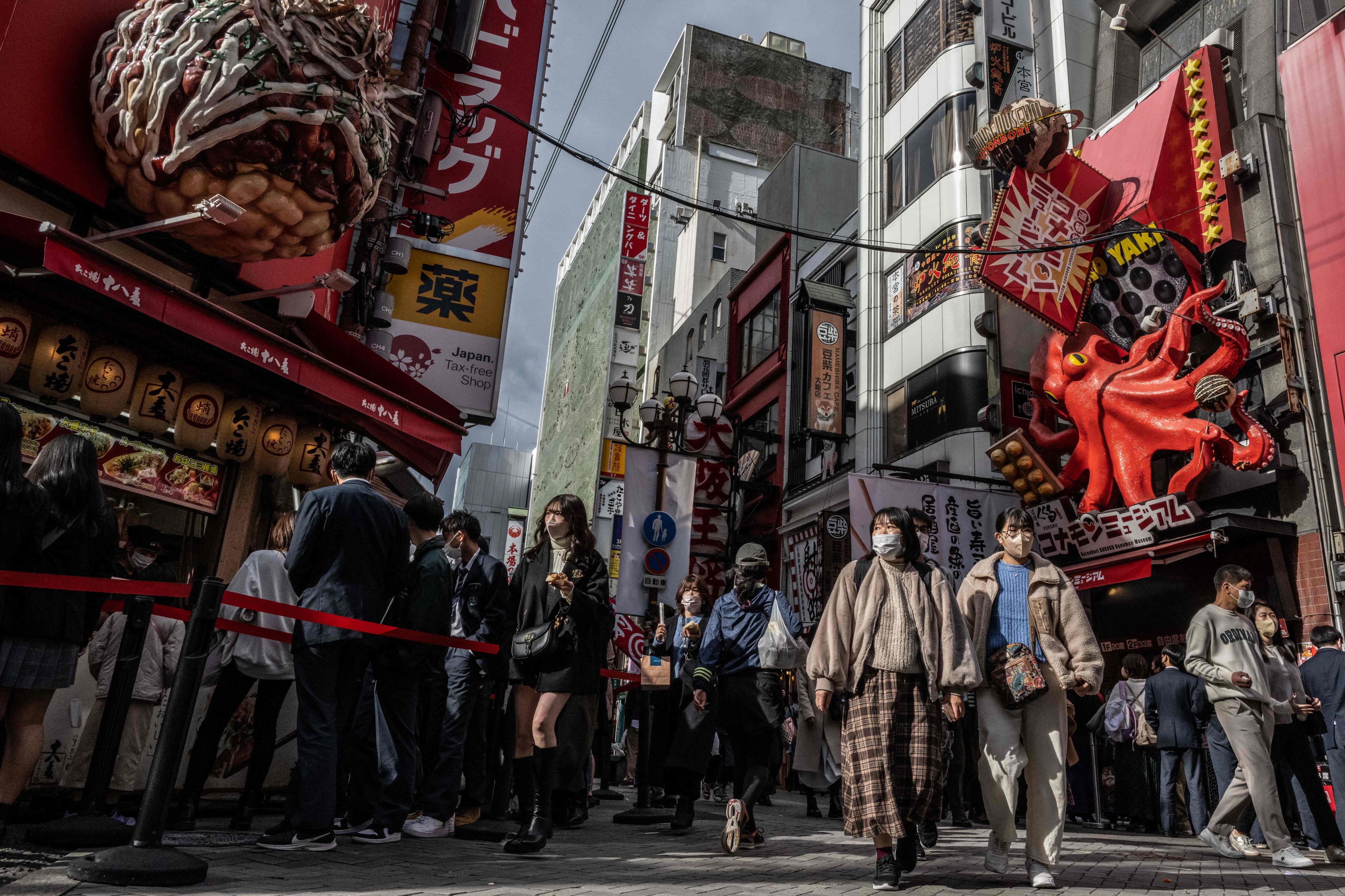 People walk through Dotonbori district in Osaka, one of four Japanese regions still permitting flights between the country and China. Photo: AFP