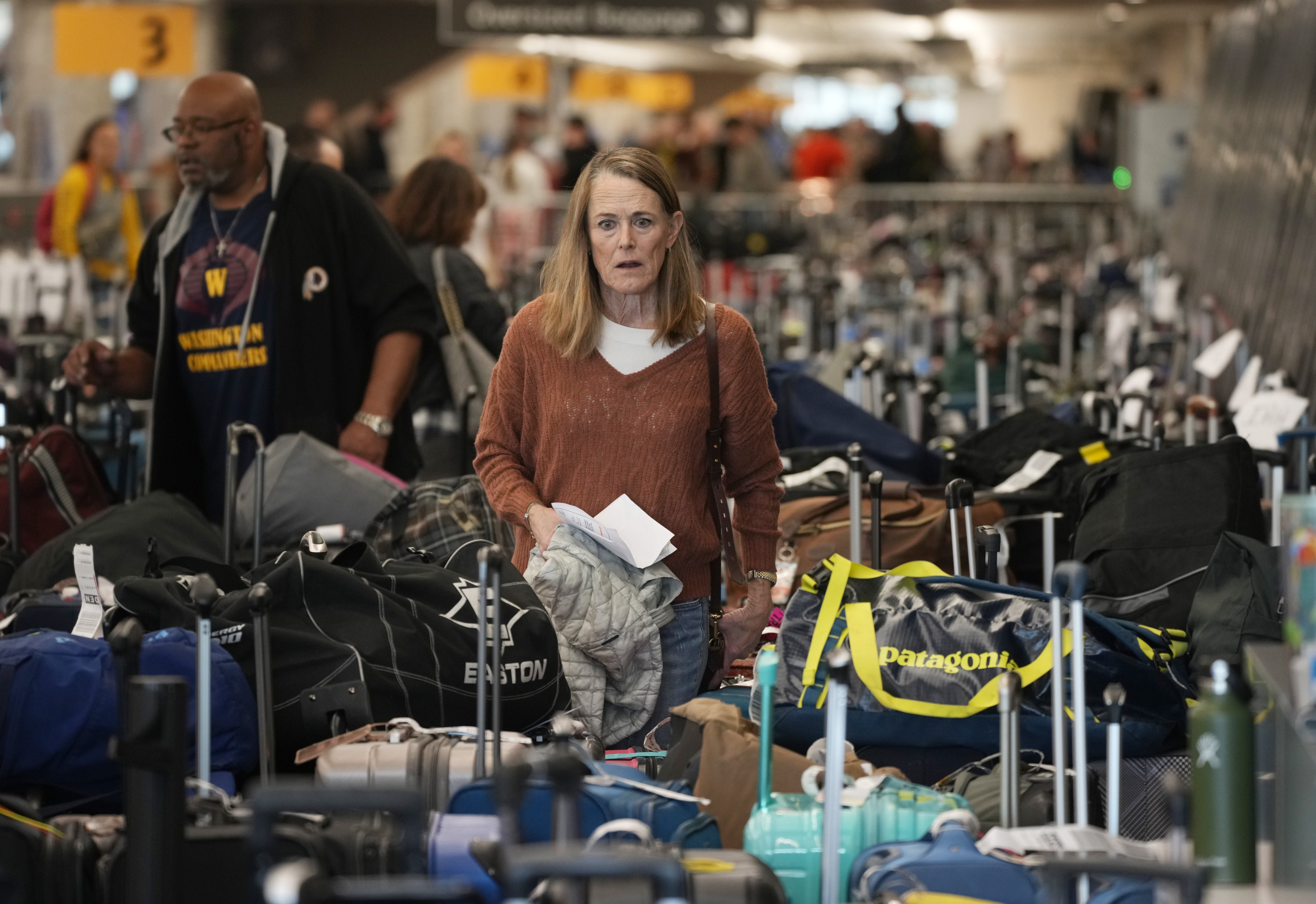 A traveler wades through the field of unclaimed bags at the Southwest Airlines luggage carousels at Denver International Airport on Tuesday. Photo: AP