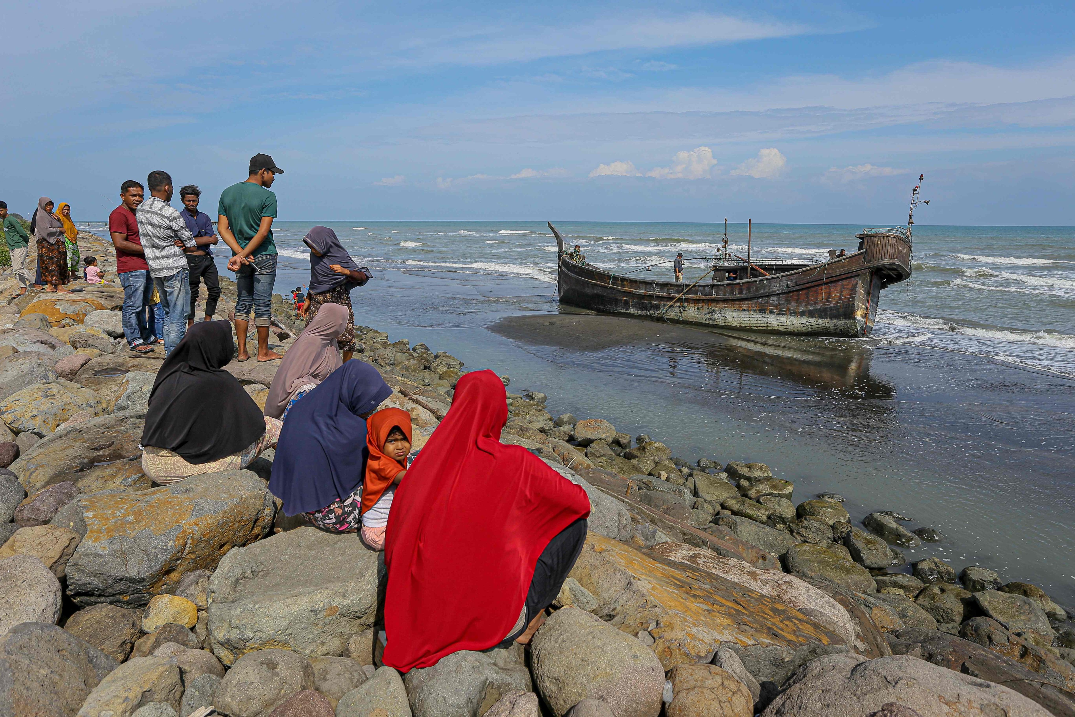 Villagers look at a wooden boat used by Rohingya people in Pidie, Aceh province on December 27, 2022. Photo: AFP