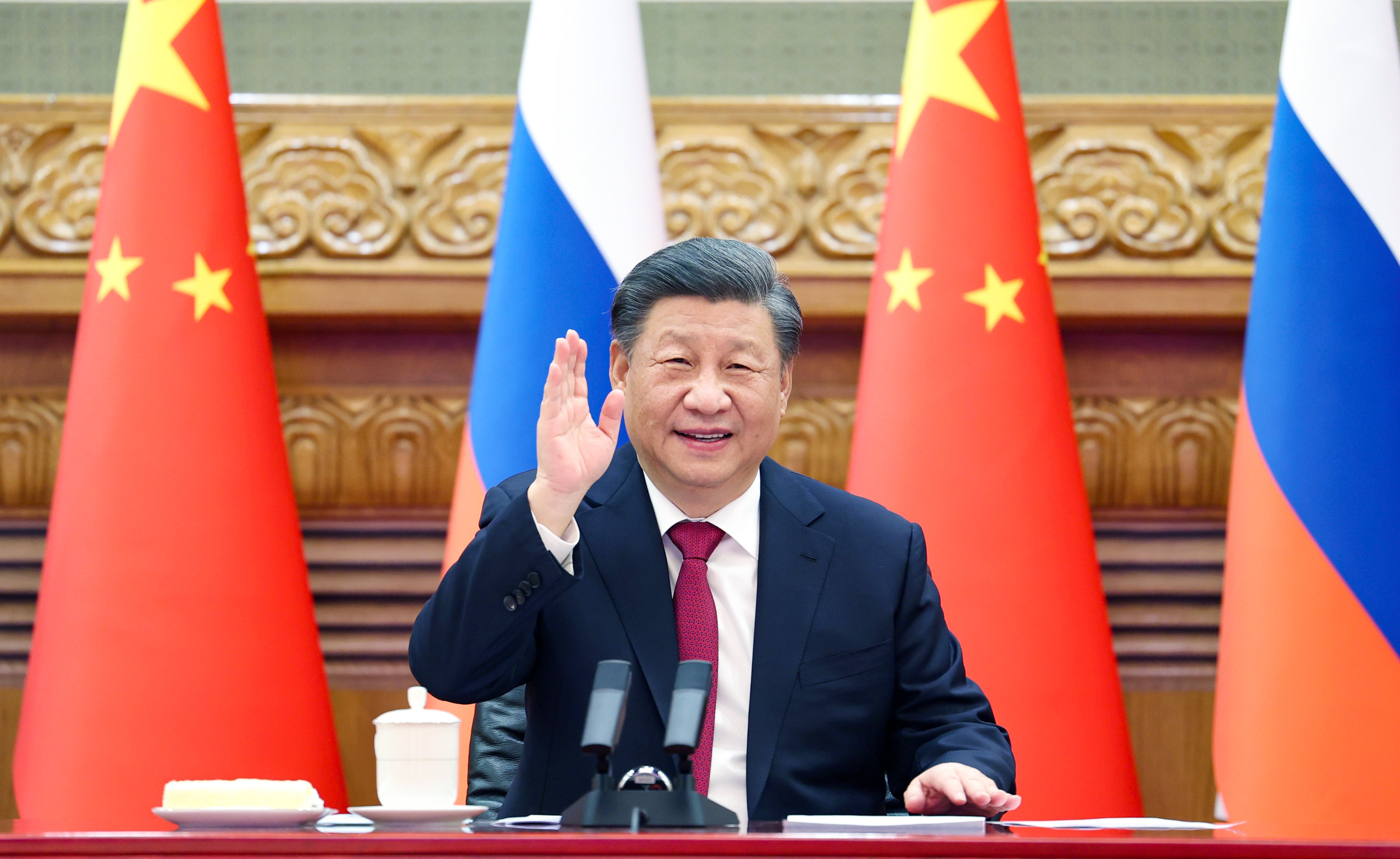 Chinese President Xi Jinping waves at the camera during Friday’s video call with Vladimir Putin. Photo: Xinhua