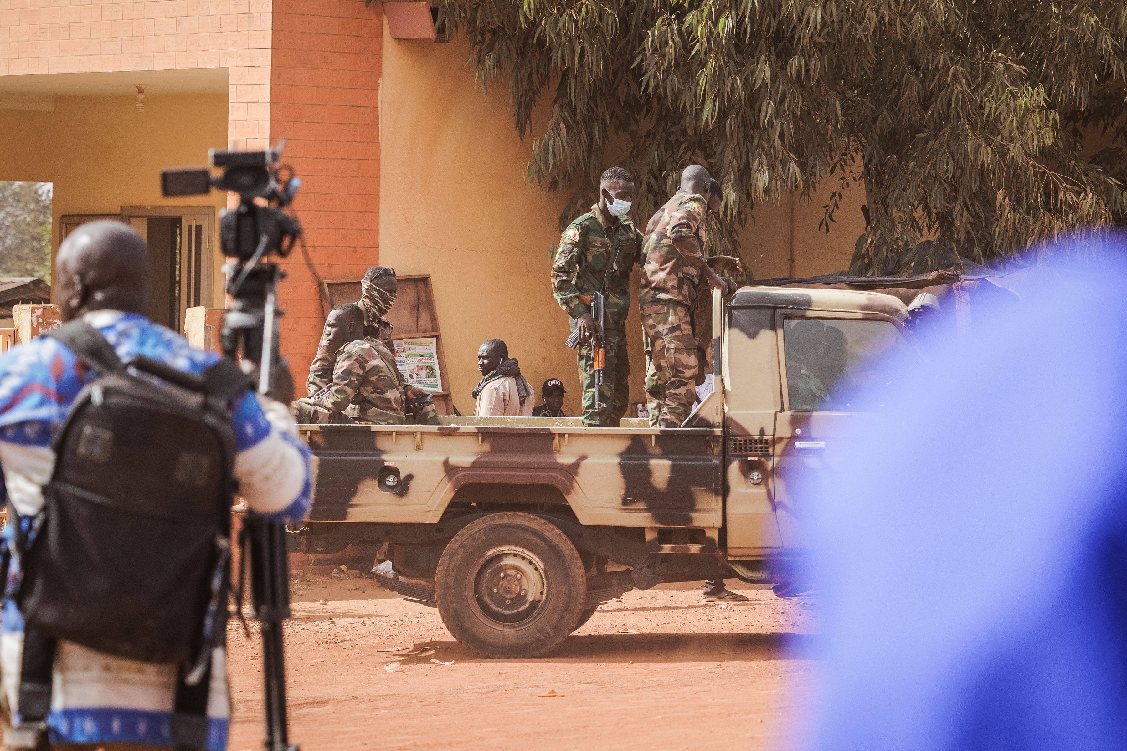Journalists and military personnel wait outside the Court of Appeal in Bamako, as the trial of the 46 Ivorian soldiers arrested in Mali takes place on Friday. Photo: AFP
