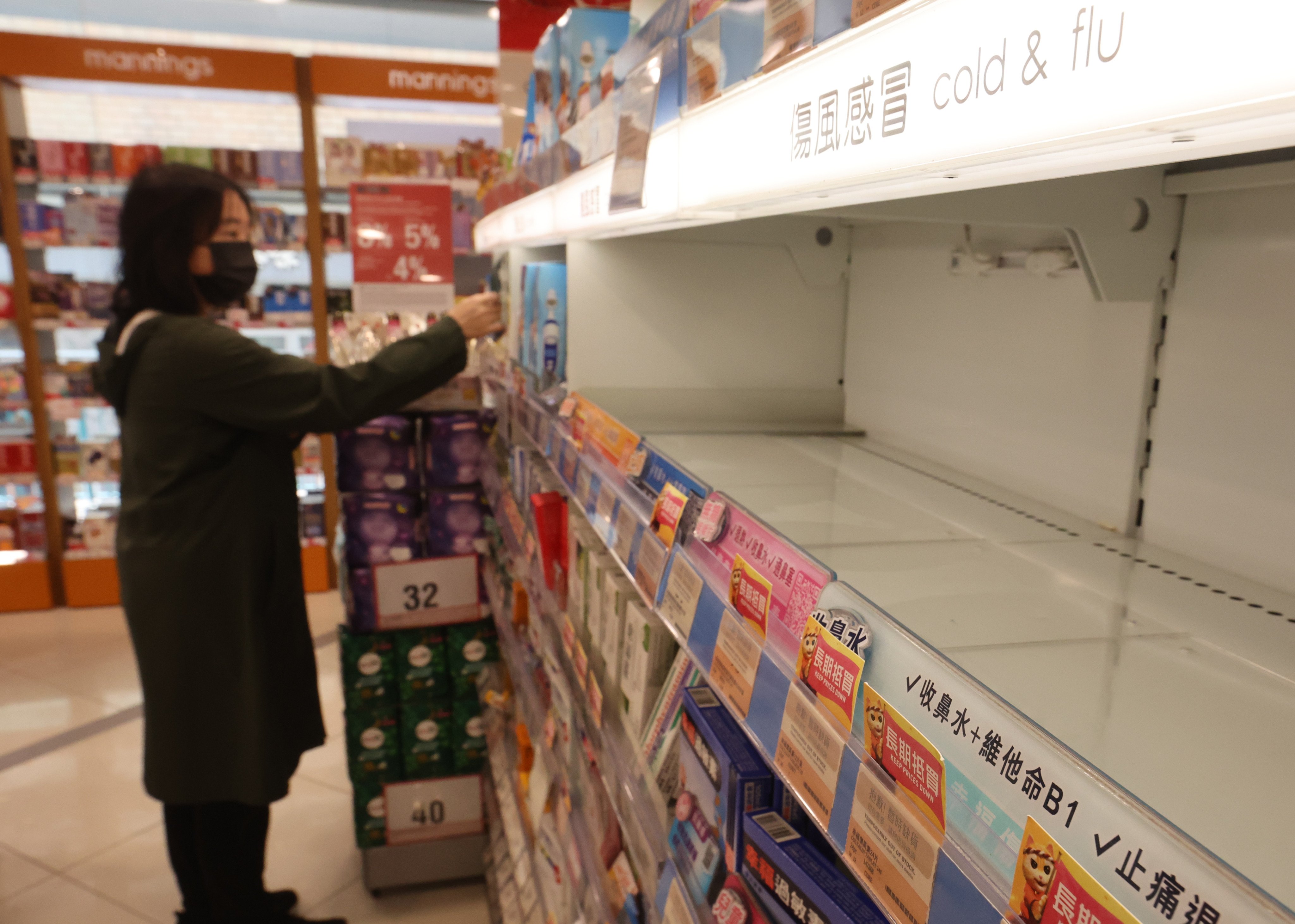 A shelf empty of painkillers and cold and flu medicine in a Kowloon Bay shop on December 27. Some Hongkongers have been snapping up fever and pain-relief drugs for their relatives and friends over the border, which has caused shortages at some pharmacies. Photo: Edmond So