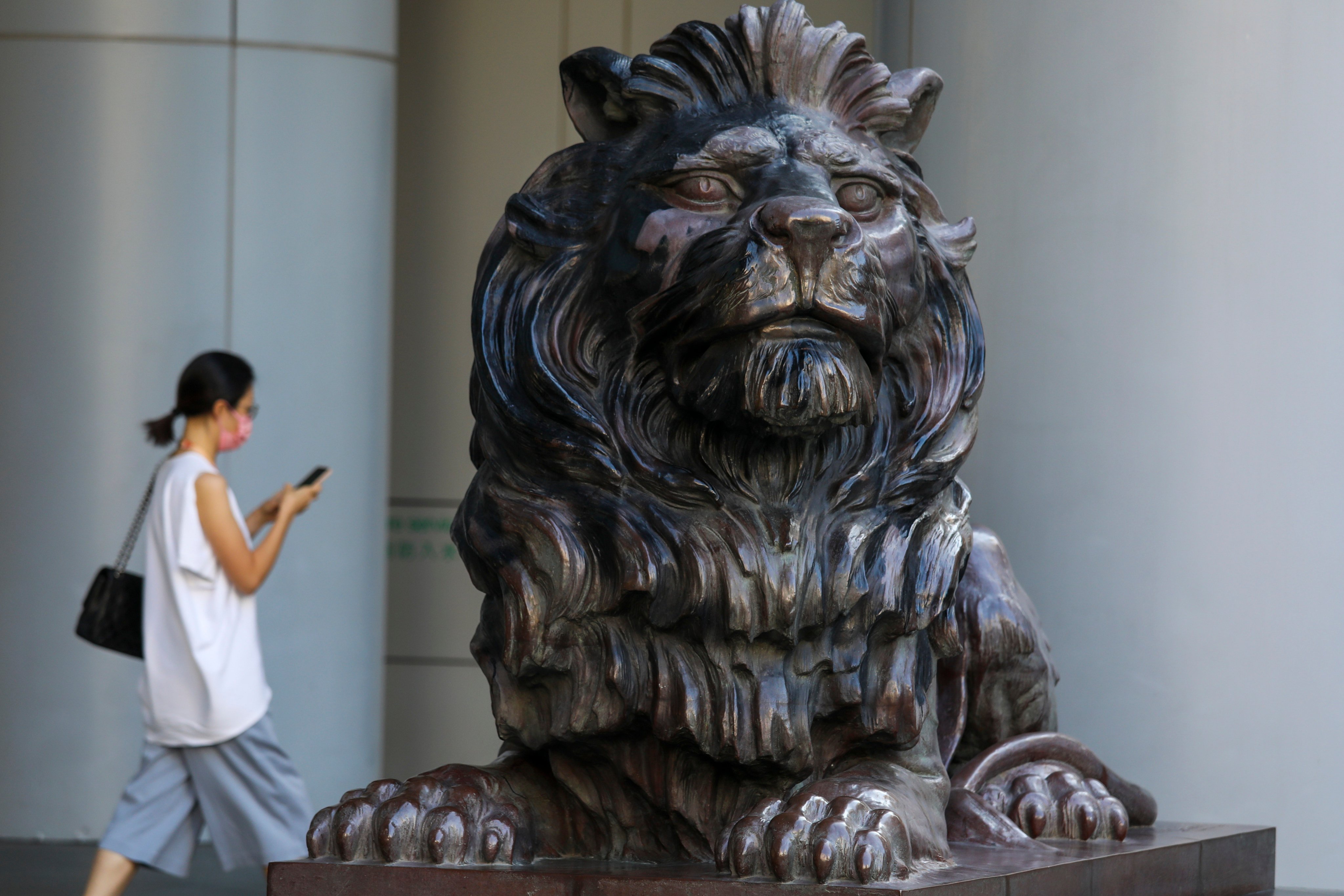 A pedestrian walks past a lion statue outside HSBC’s headquarters in Hong Kong. Rising interest rates are likely to boost the bank’s profits this year. Photo: Yik Yeung -man