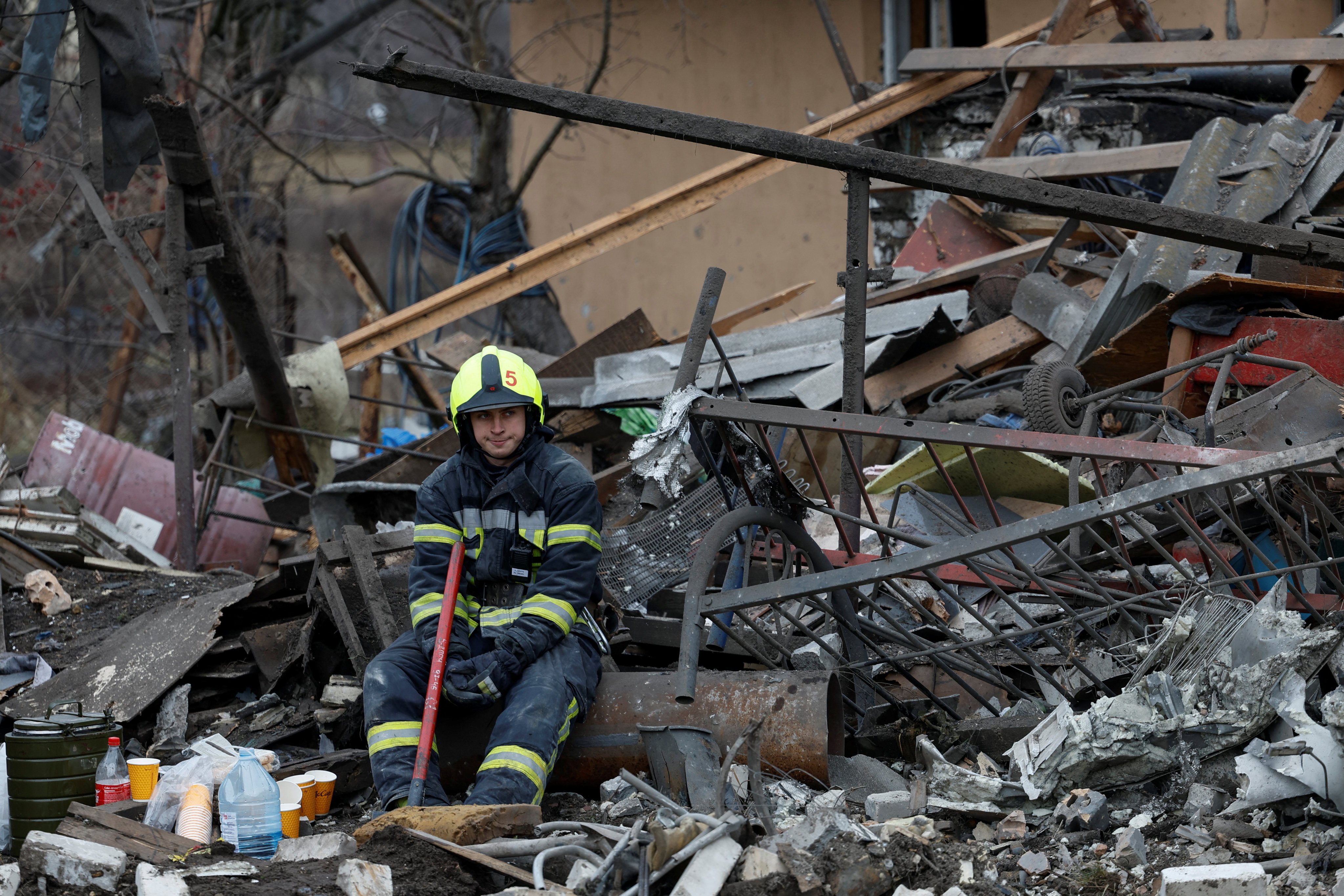 A rescuer rests at a site of a residential house damaged during Russia’s attack on Kyiv, Ukraine, on December 29. Photo: Reuters