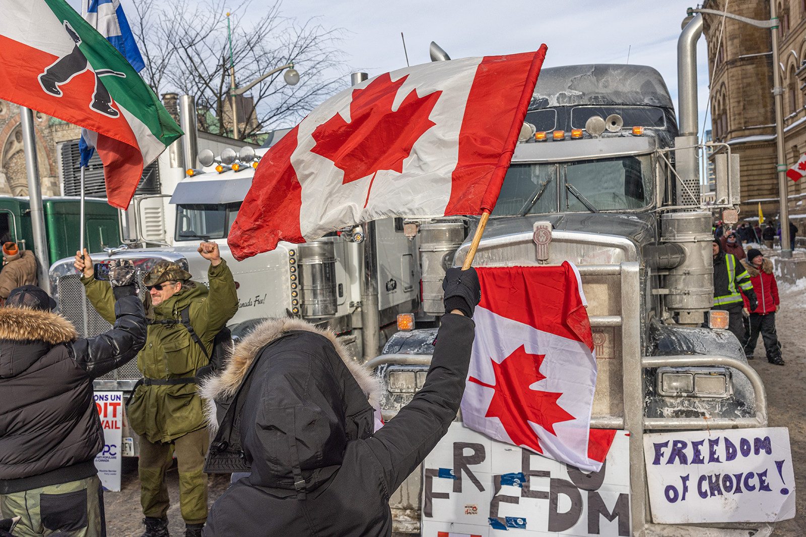 A woman waves a flag and cheers on truckers in protest of Covid-19 vaccine mandates in Ottawa, Canada, in January 2022. Photo: TNS
