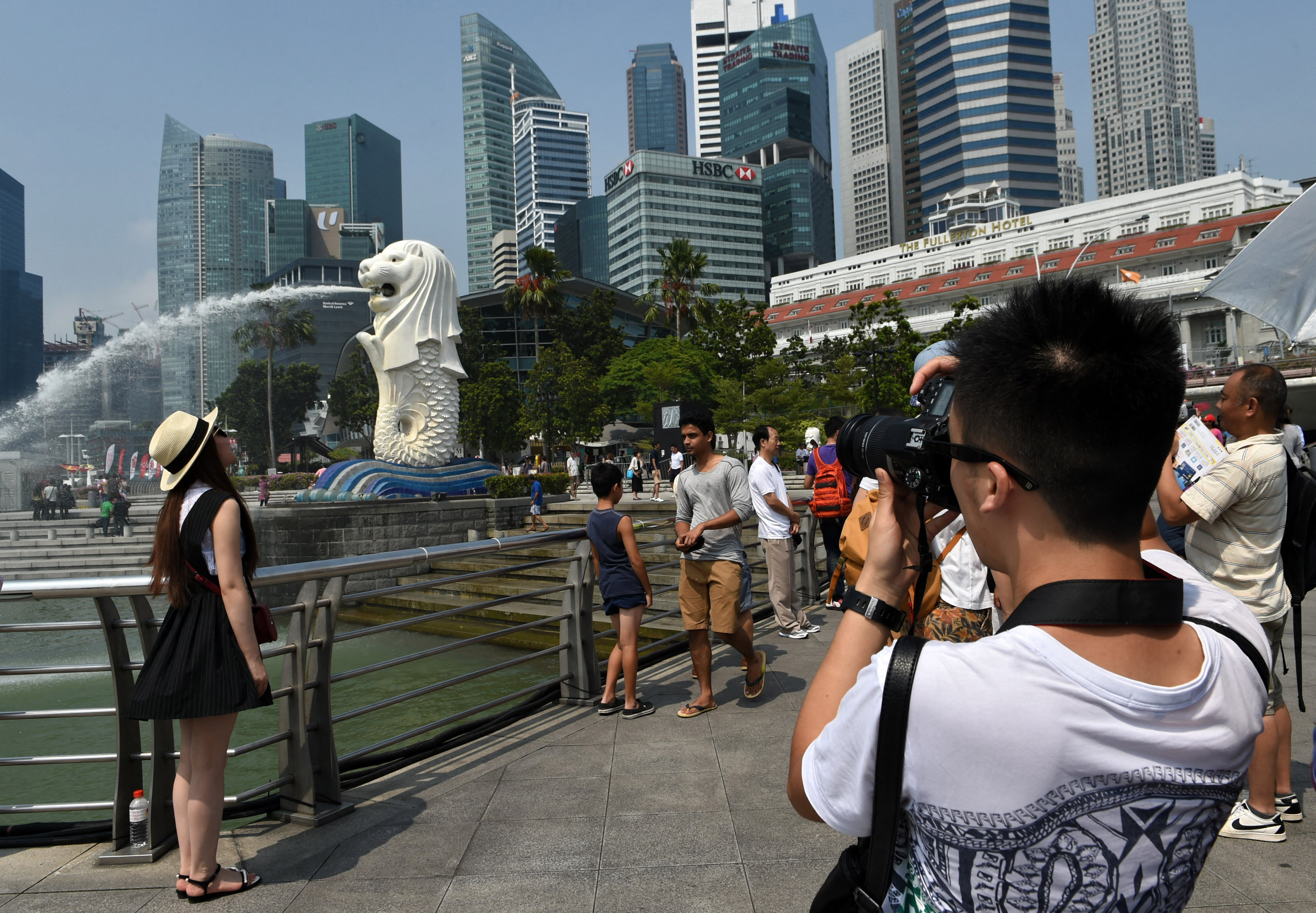 A Chinese tourist takes photos of the iconic Merlion statue in Singapore in 2015. Photo: AFP