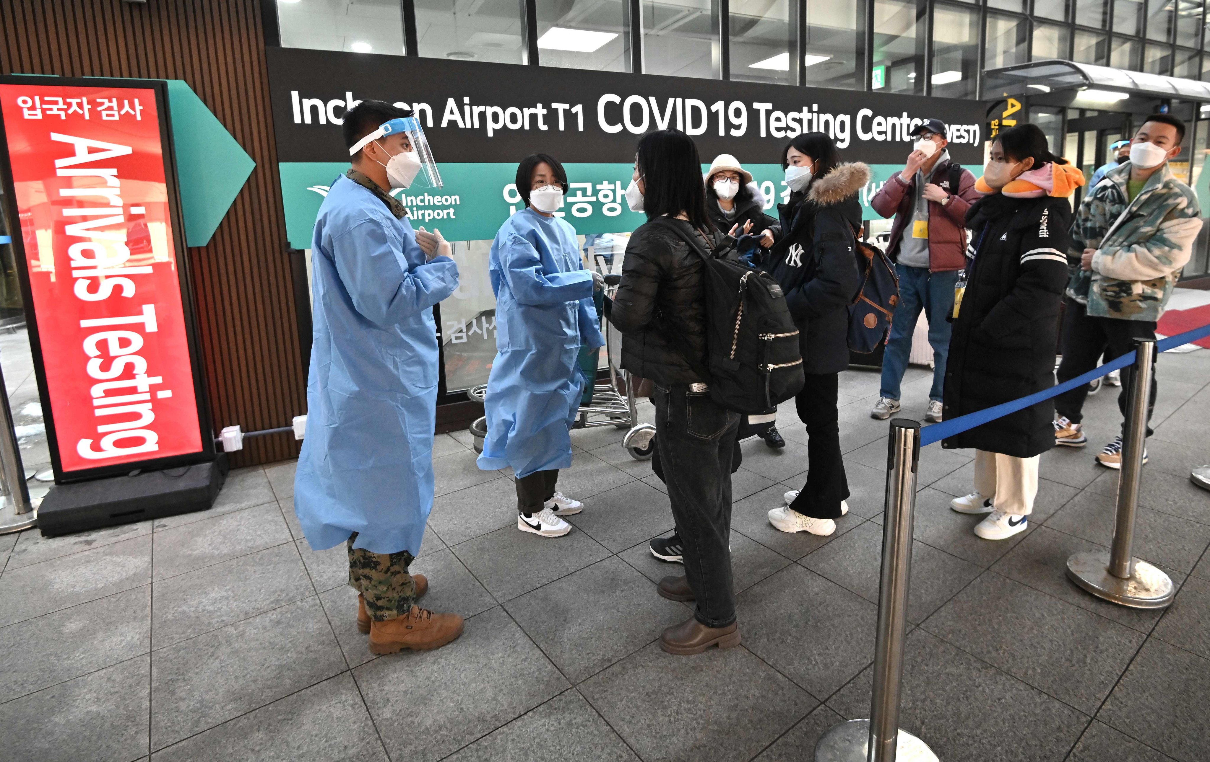Health workers direct travellers arriving from China to a Covid-19 testing centre at Incheon International Airport on Tuesday. Photo: AFP