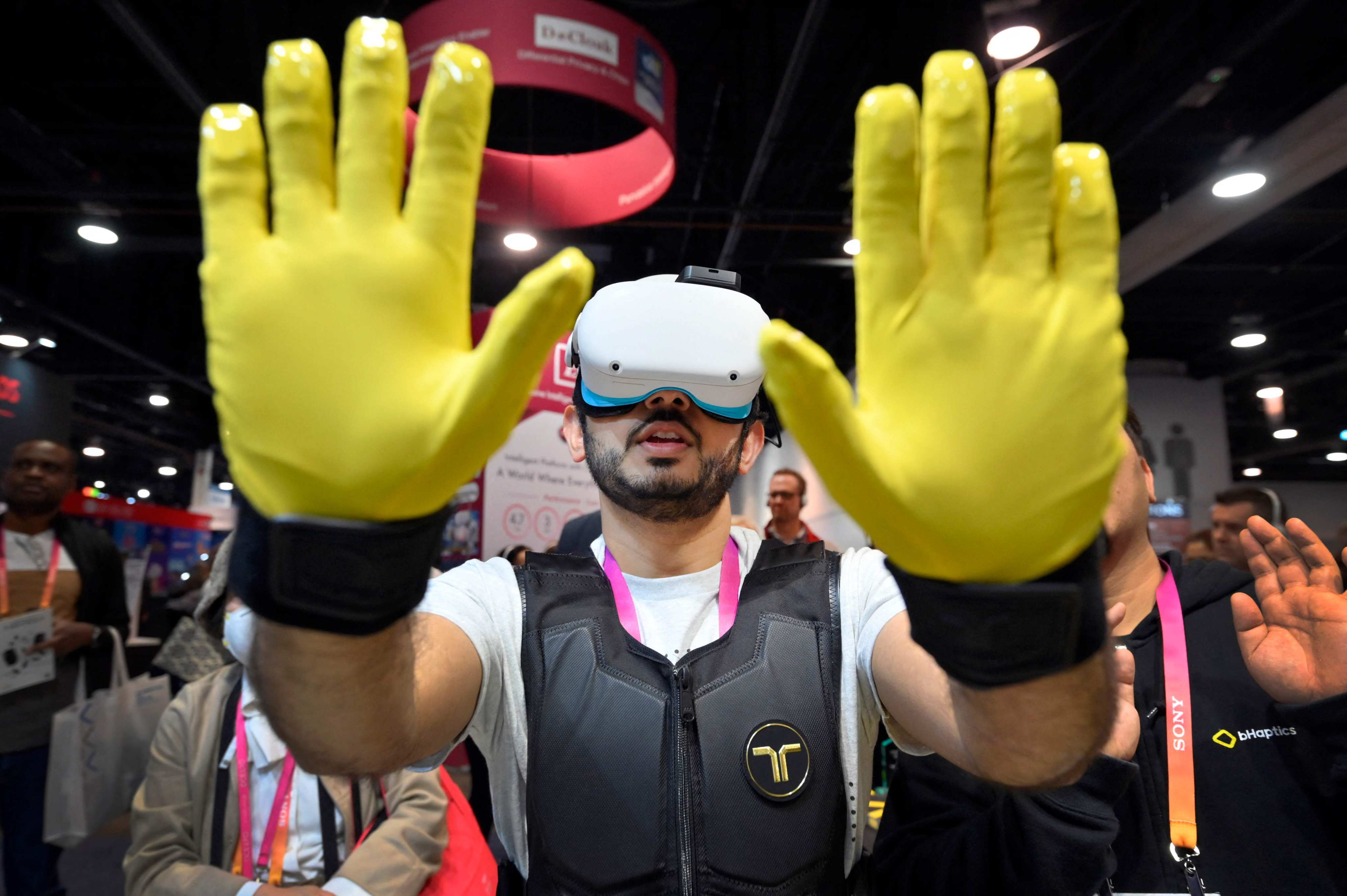 An attendee uses tactile gloves and vest during a VR demonstration at the bHaptics booth during CES 2023 at the Las Vegas Convention Center on January 6. Photo: Getty Images via AFP