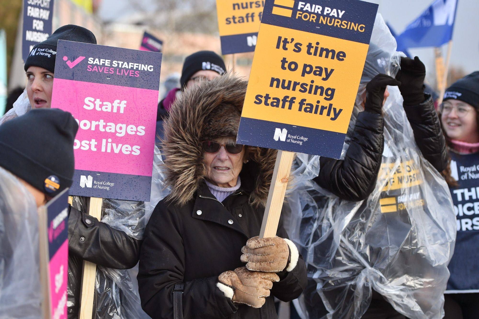 Demonstrators hold placards on a picket line during a strike by NHS nursing staff in Liverpool, UK on December 20. Photo: Bloomberg