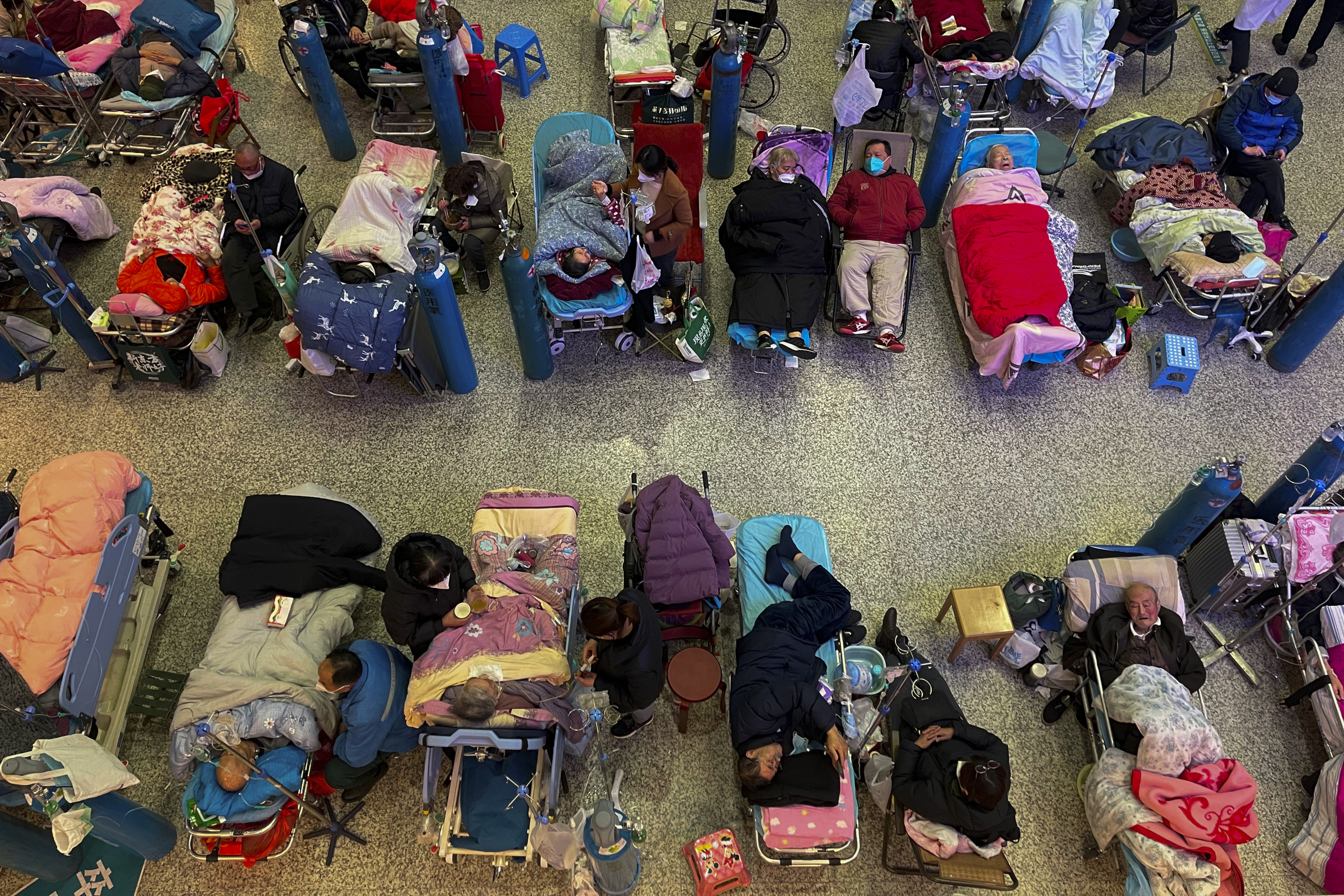 People look after their elderly relatives lying on stretchers and receiving intravenous drips at the Changhai Hospital hall in Shanghai on January 3. Photo: AP