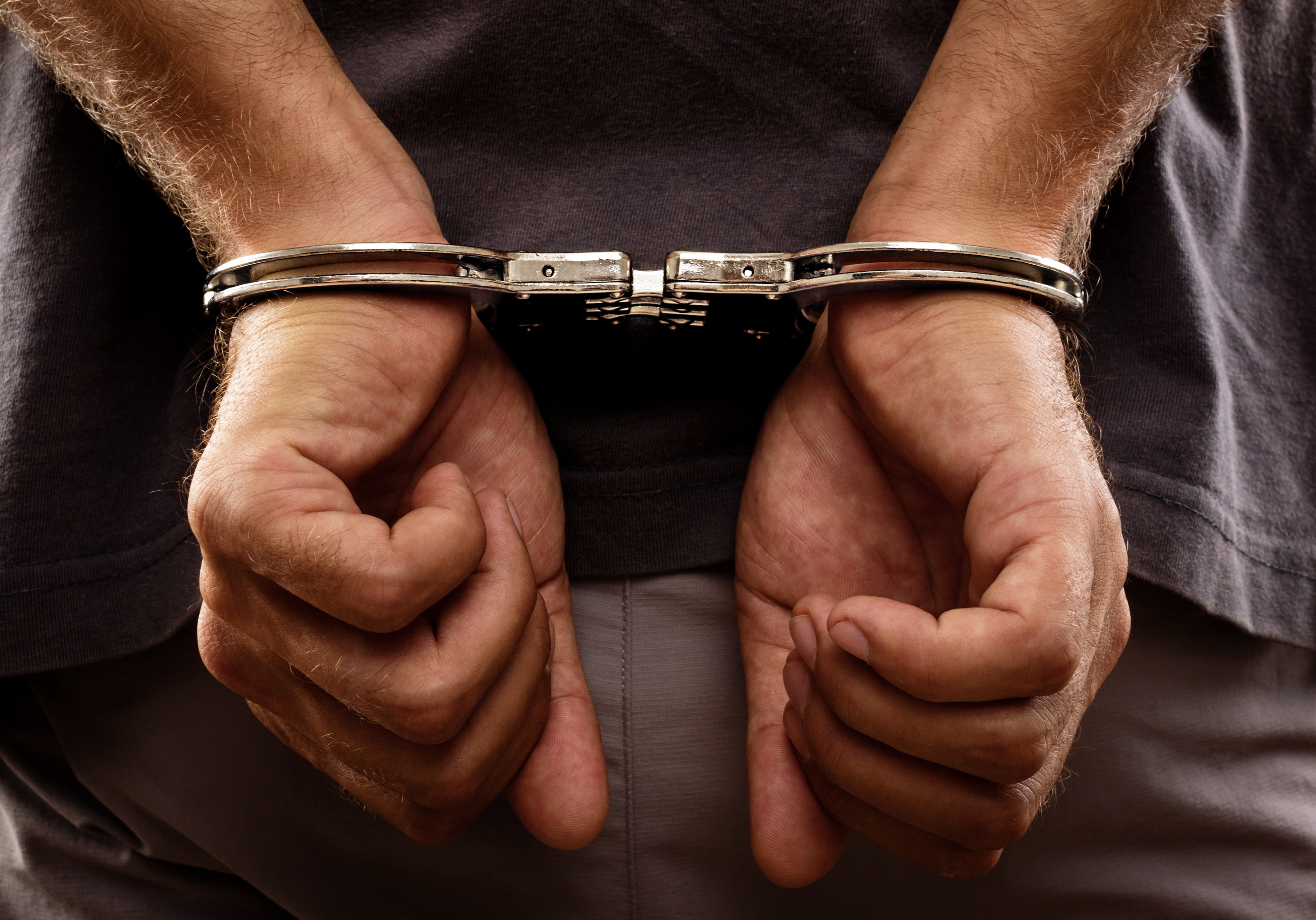 Arrested man handcuffed hands at the back. Photo: Shutterstock/File
