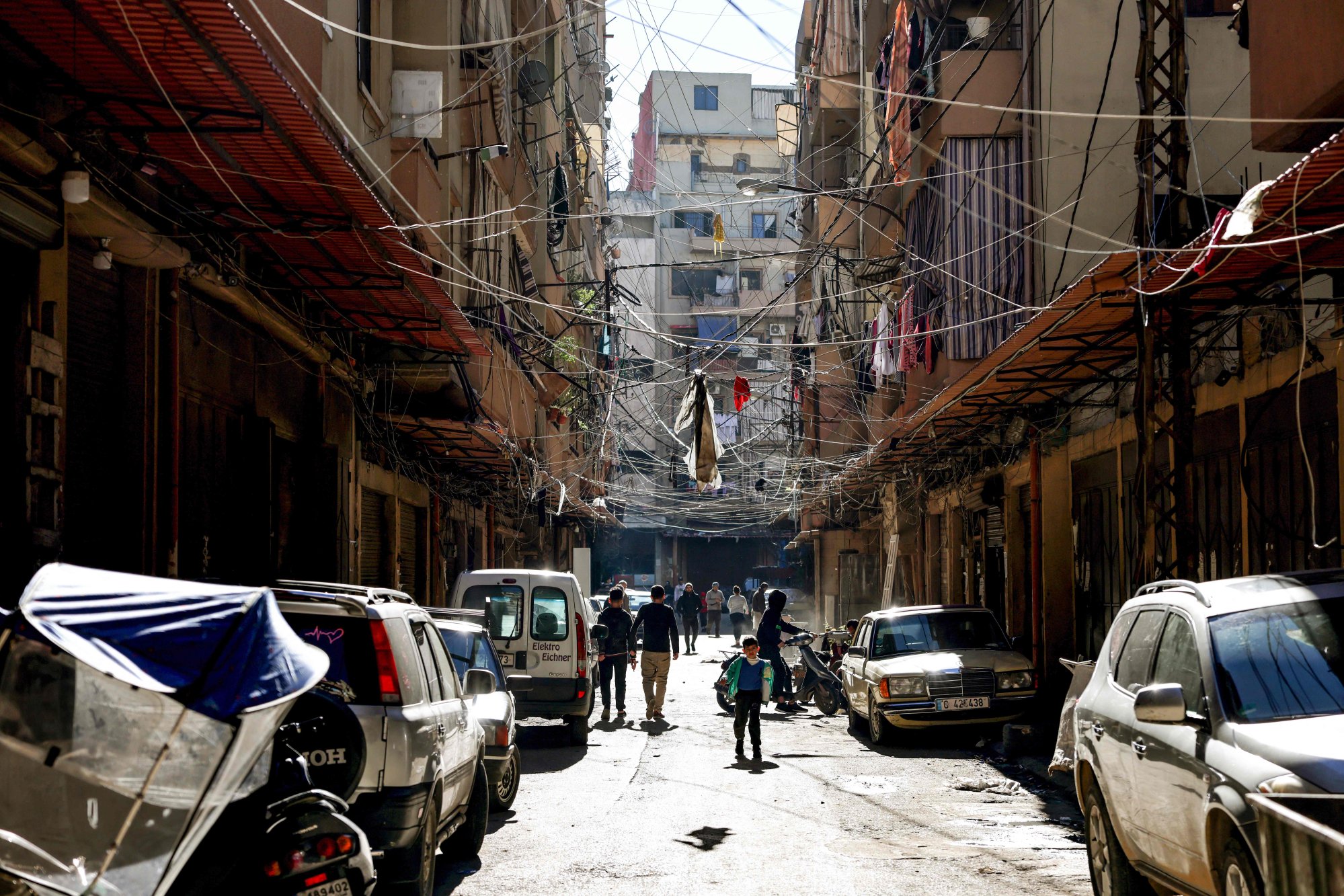 People gather in the impoverished neighbourhood of Bab al-Tabbaneh, in the northern Lebanese city of Tripoli, on January 17, 2022. Lebanon is one of several countries that has defaulted on its debt during the pandemic years. Photo: AFP