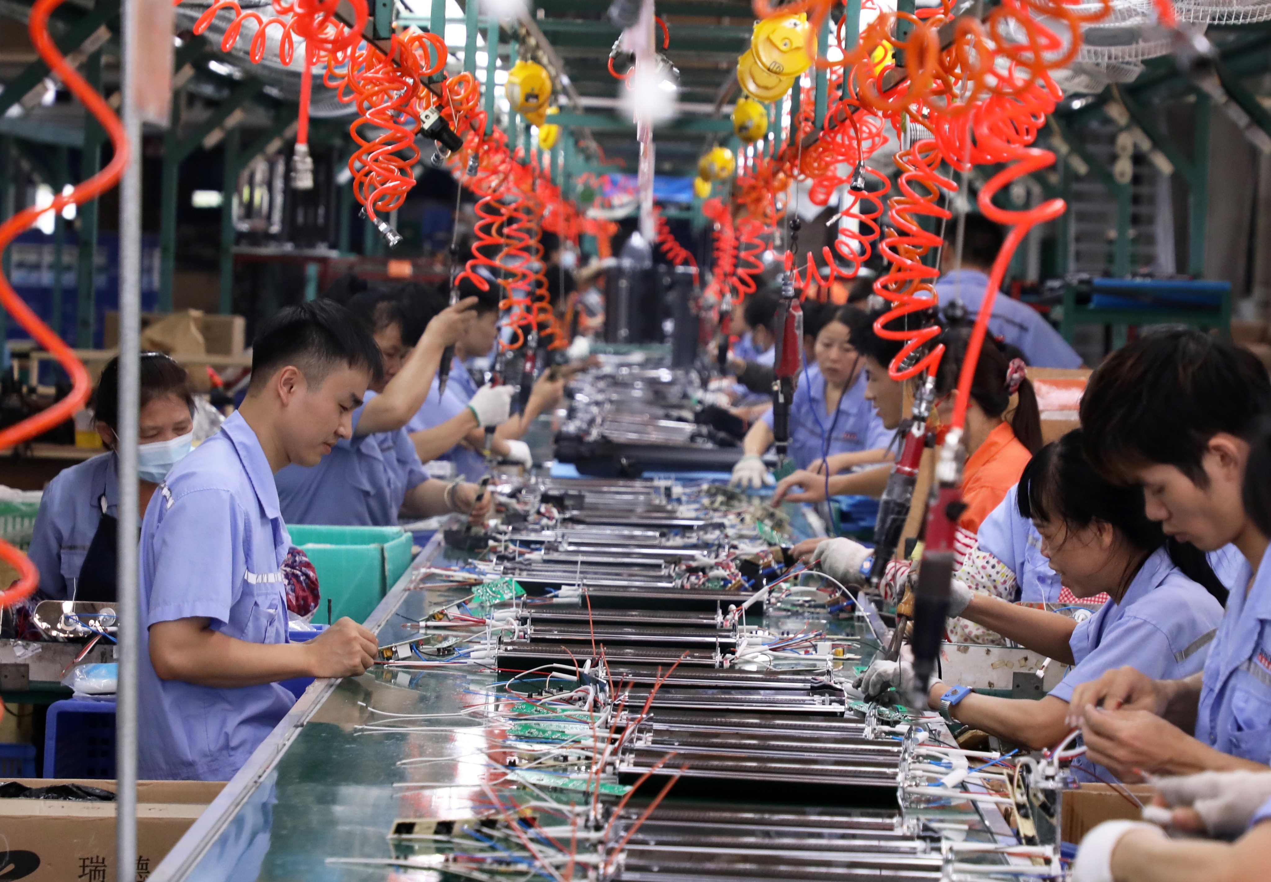 Factory workers build electric heaters in China’s Guangdong province, where authorities say they will splash out billions this year on programmes to attract foreign investment. Photo: Xinhua