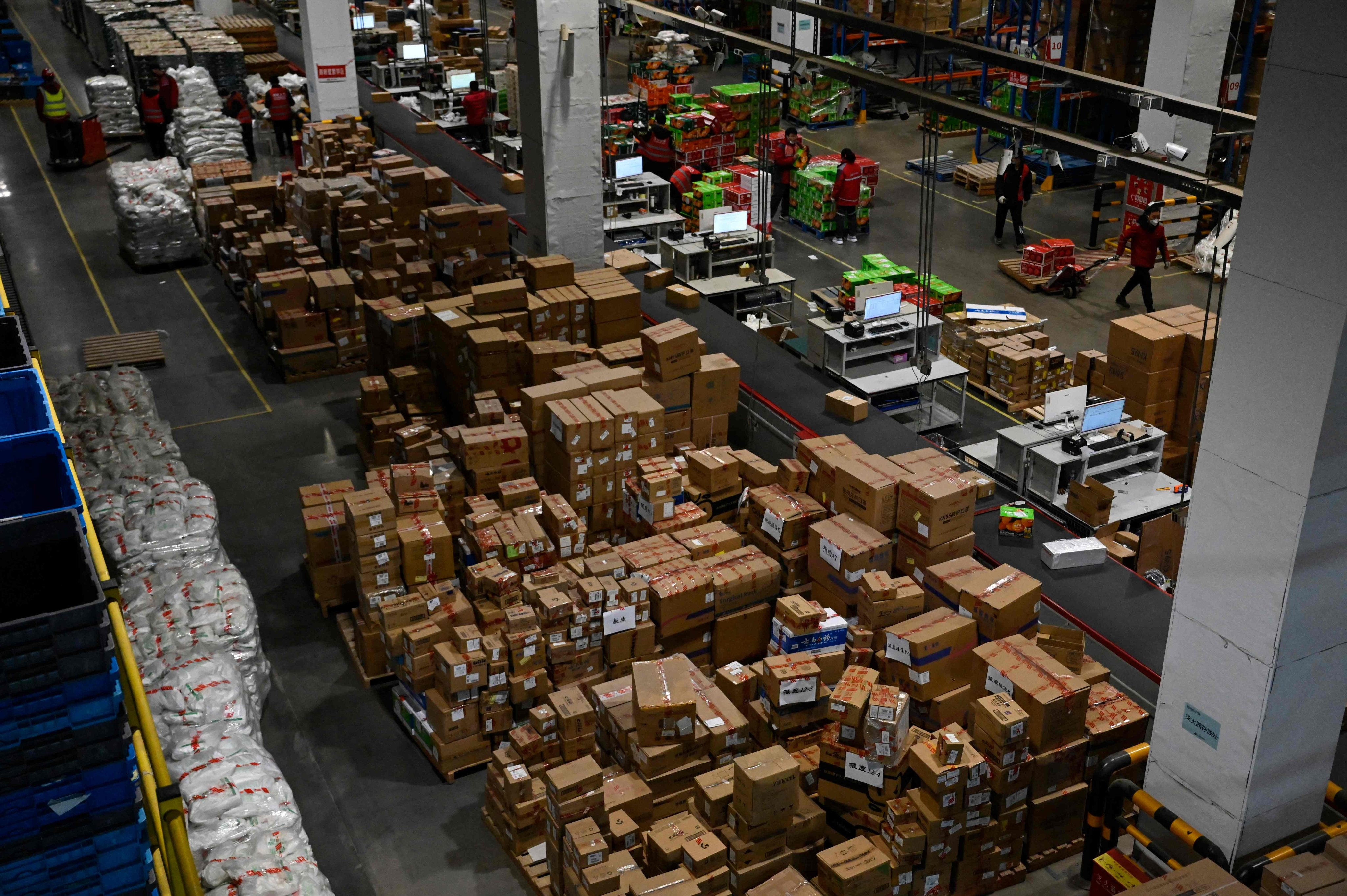 Workers sort packages for delivery at a JD.com warehouse in Beijing on January 10. With further fiscal and monetary support, China’s economy should see a stronger rebound in the second half of the year. Photo: AFP