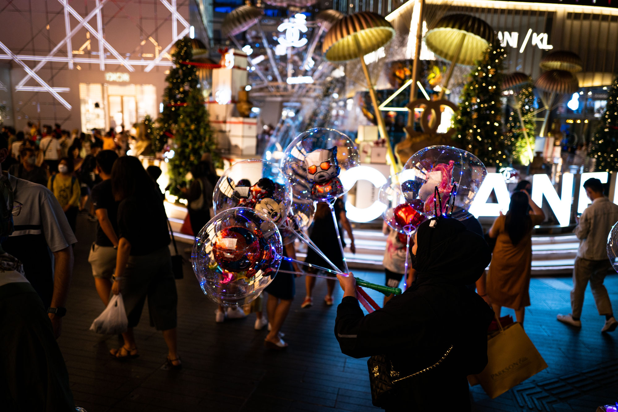A woman sells balloons outside a shopping centre in Kuala Lumpur. Not everyone is unhappy with the tax. Some say it levels the playing field for importers. Photo: Xinhua