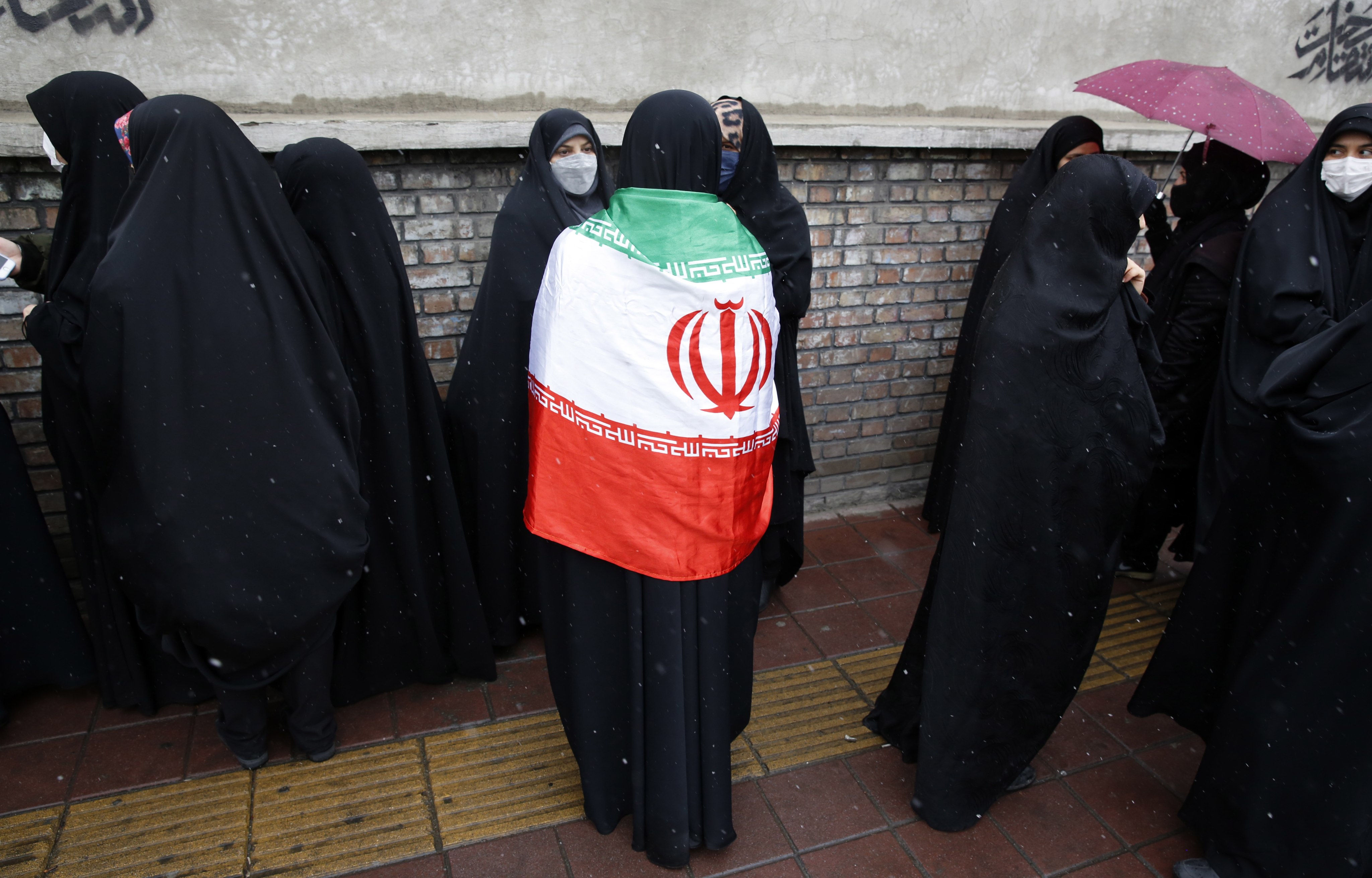 A woman wears the Iranian national flag during a protest outside the French embassy in Tehran, Iran on January 11, 2023. Photo: EPA-EFE