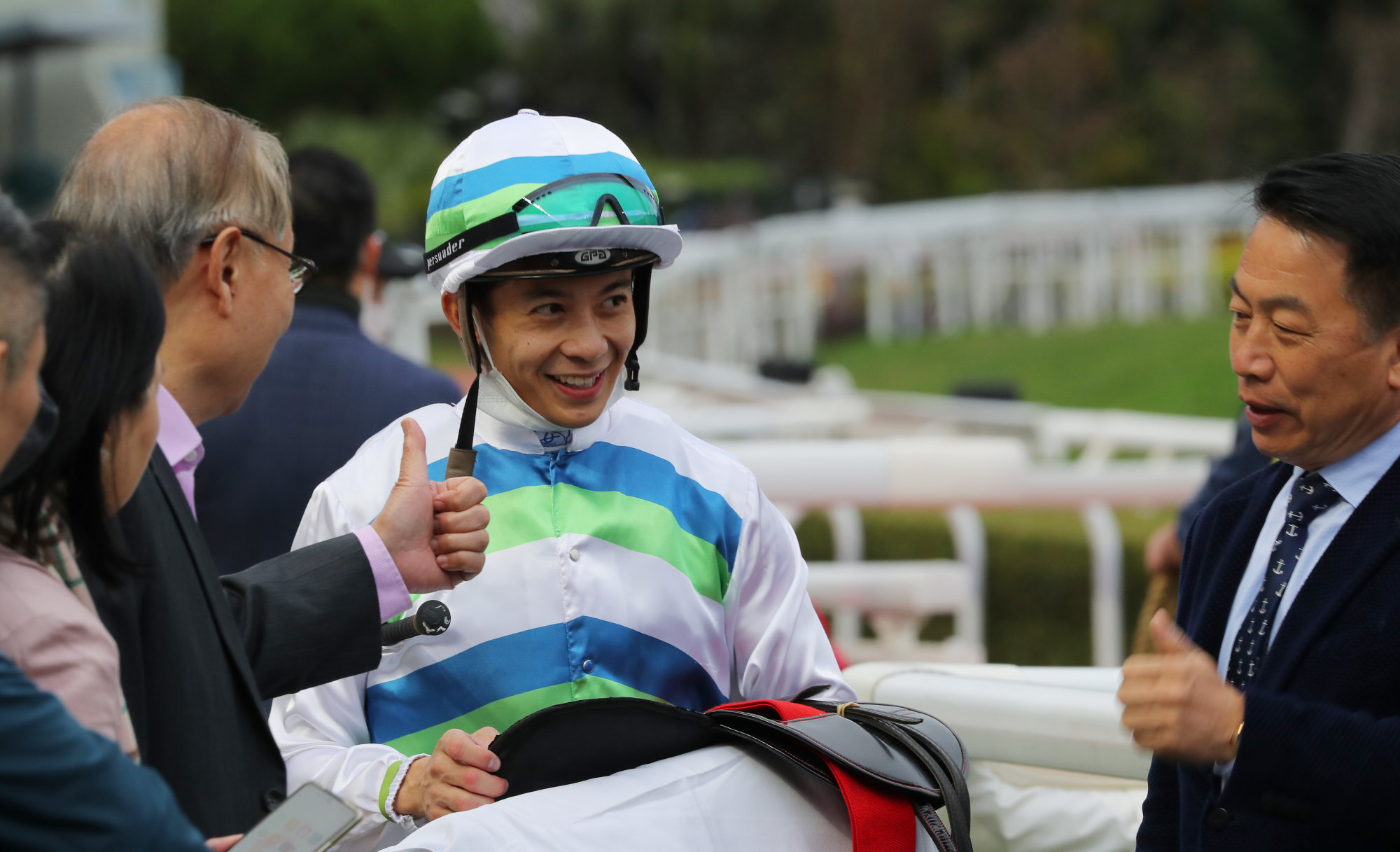 Jockey Derek Leung and trainer Ricky Yiu enjoy Voyage Bubble’s victory with connections.