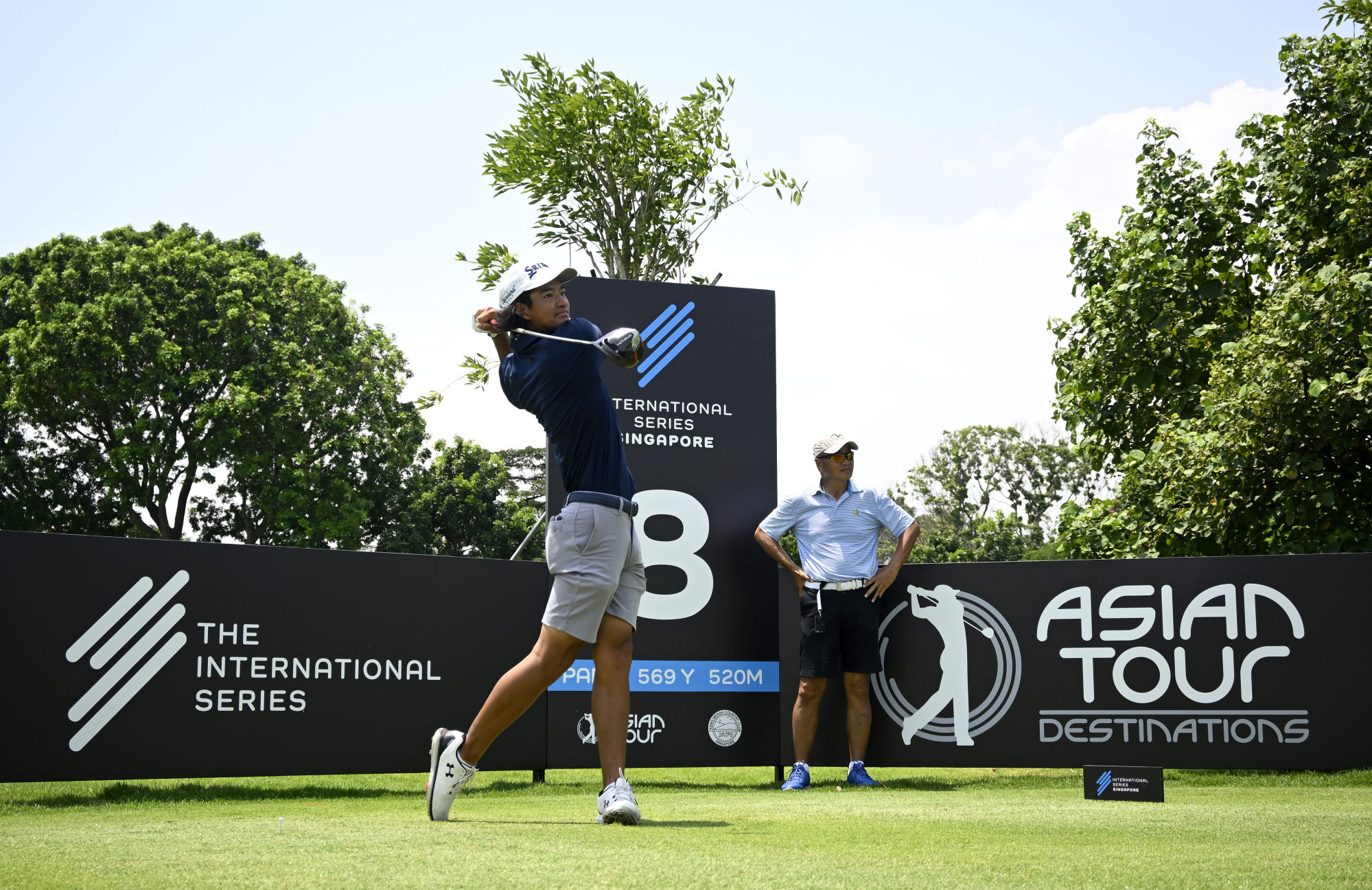 Hong Kong’s Taichi Koh tees off during an official practice round, as his father and caddie Victor Koh looks on, ahead of the International Series Singapore event. Photo: Asian Tour