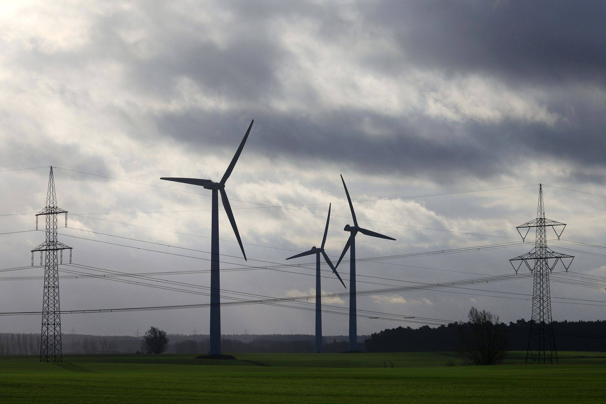 Wind turbines and high voltage electricity transmission towers in Germany. Investments in renewables need to triple by 2030 if climate targets are to be met, experts have warned. Photo: Bloomberg