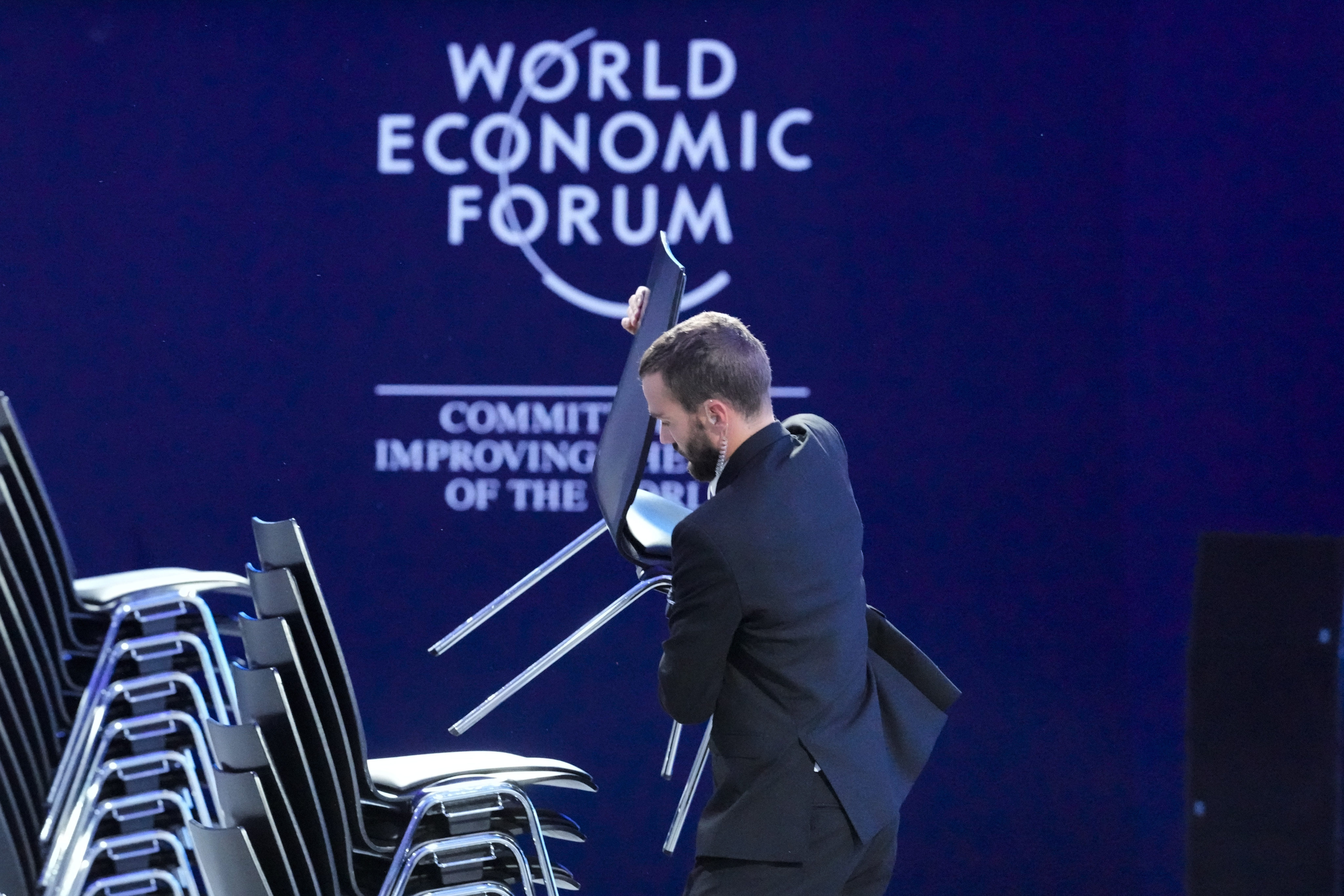 A man stacks chairs on Friday during the clean-up in the congress hall after the World Economic Forum in Davos, Switzerland. Photo: AP 