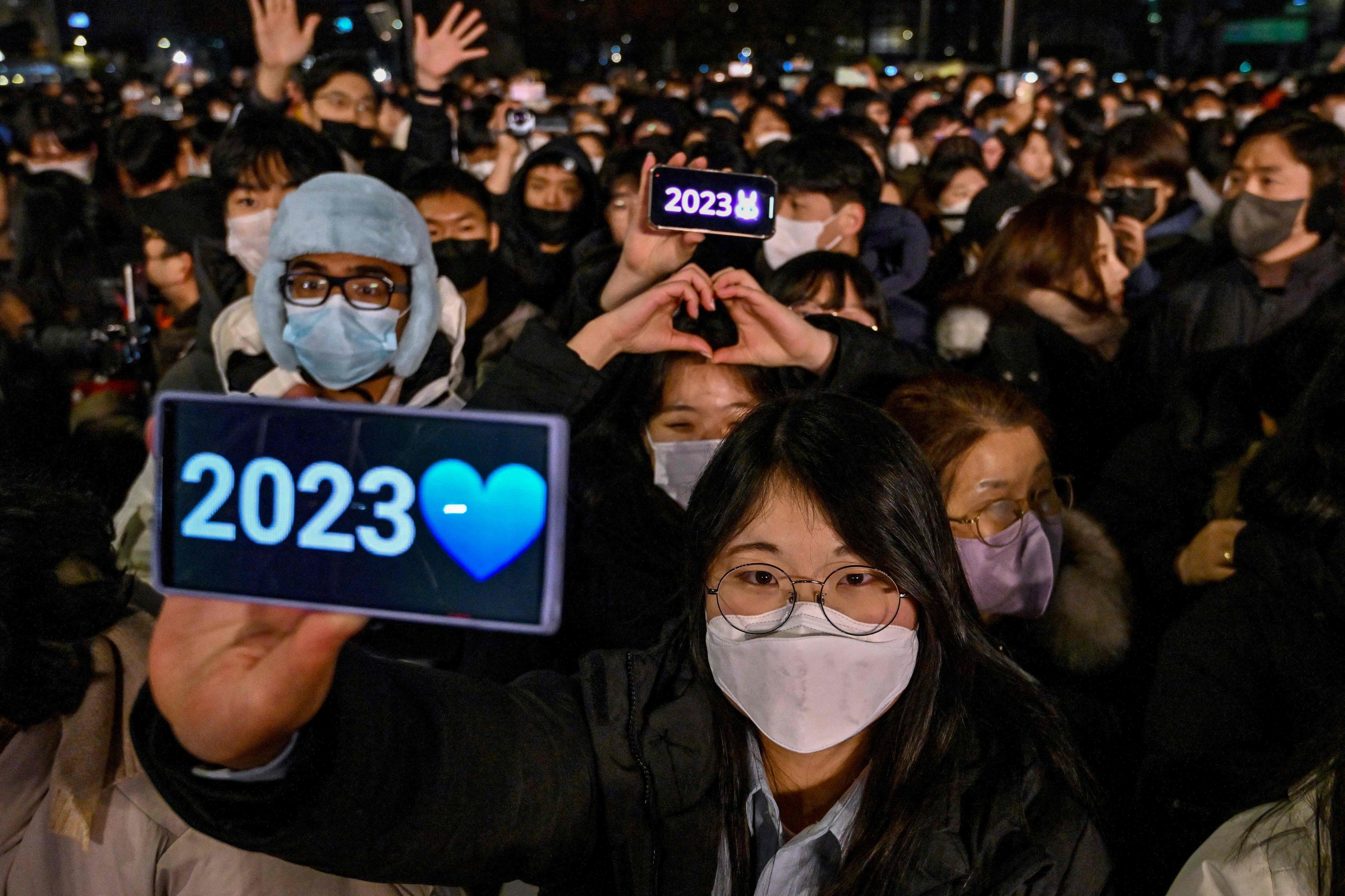 People celebrate on New Year’s Eve in central Seoul. South Korea ended its outdoor mask mandate in September, but many people still choose to wear masks outside. Photo: AFP
