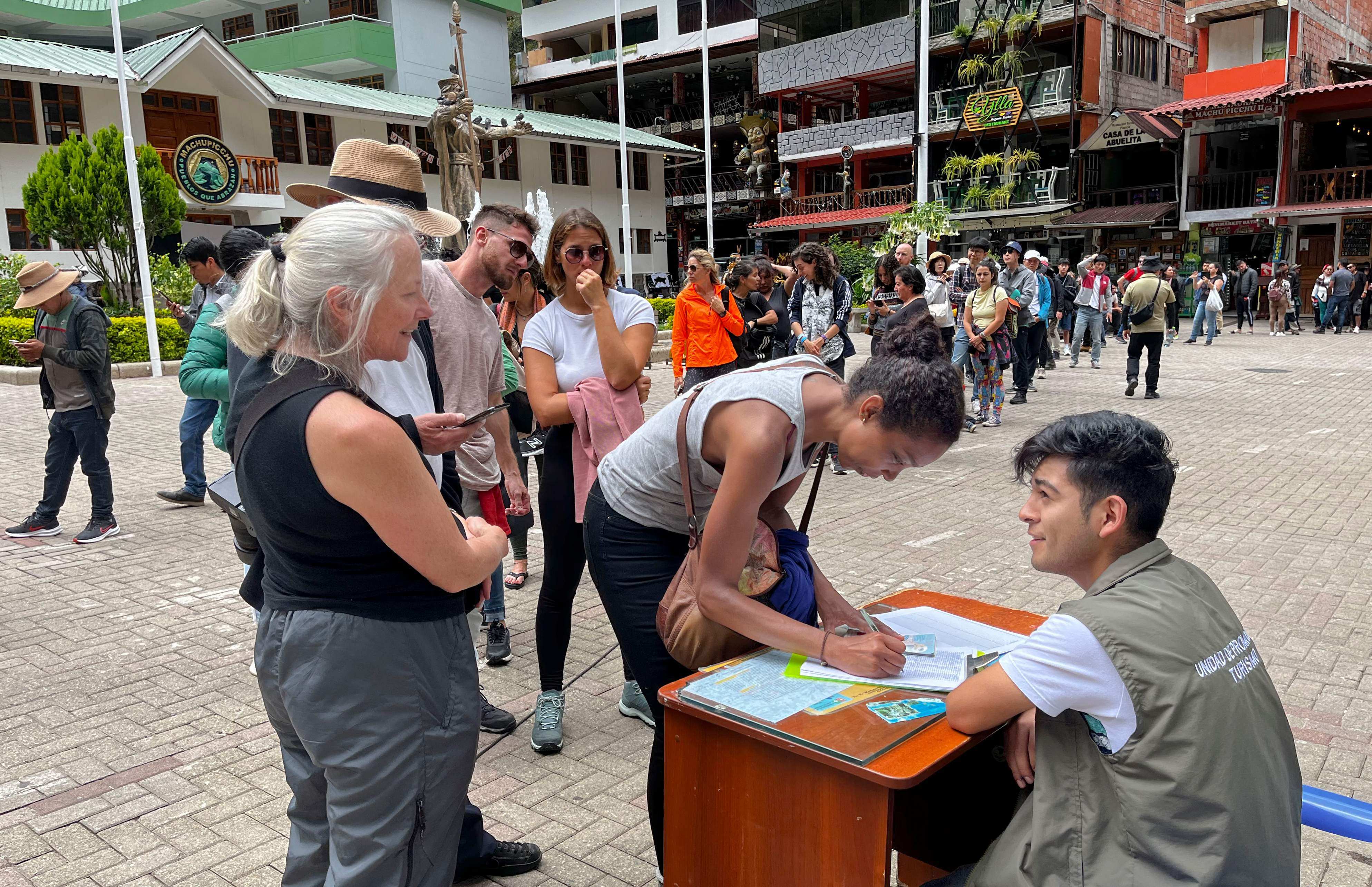 Tourists queue to sign a petition to the rail company to be evacuated on a “humanitary train” in Machu Picchu, Peru on Friday. Photo: AFP