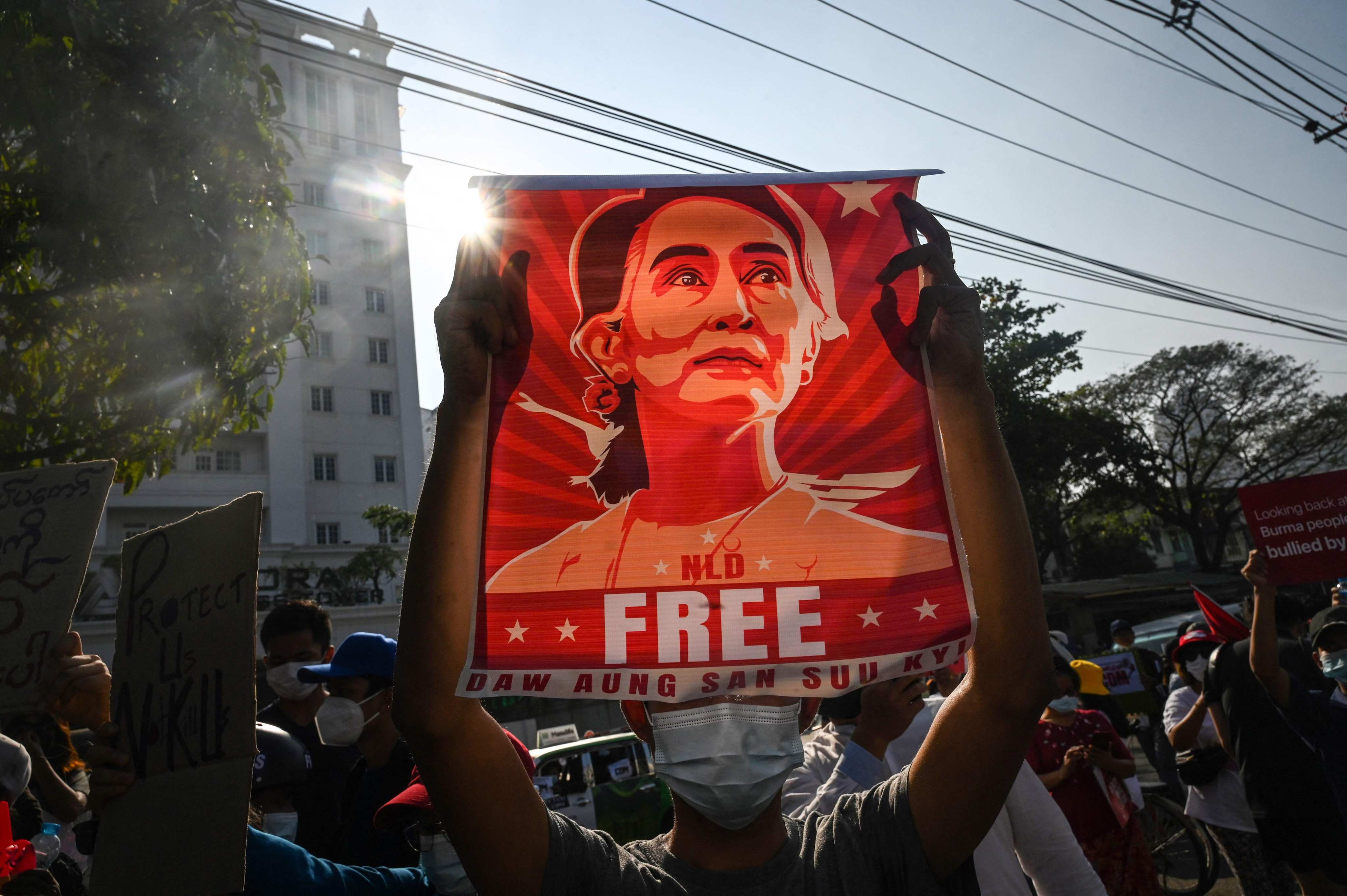 A Myanmar protester holds a banner featuring deposed civilian leader Aung San Suu Kyi during a 2021 demonstration against the brutal military coup. File photo: AFP