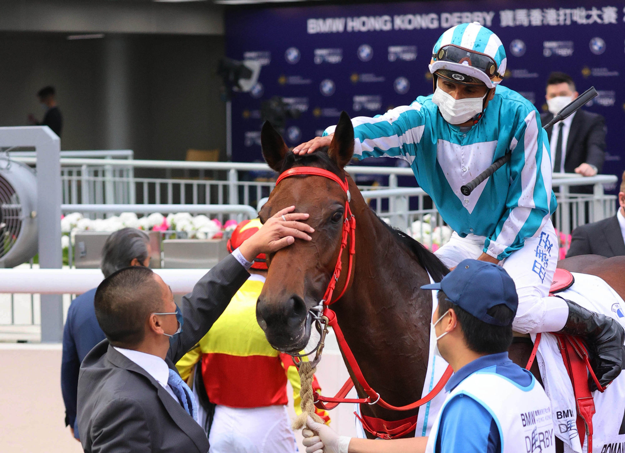 Trainer Danny Shum and jockey Karis Teetan give Romantic Warrior a pat after his Hong Kong Derby victory.