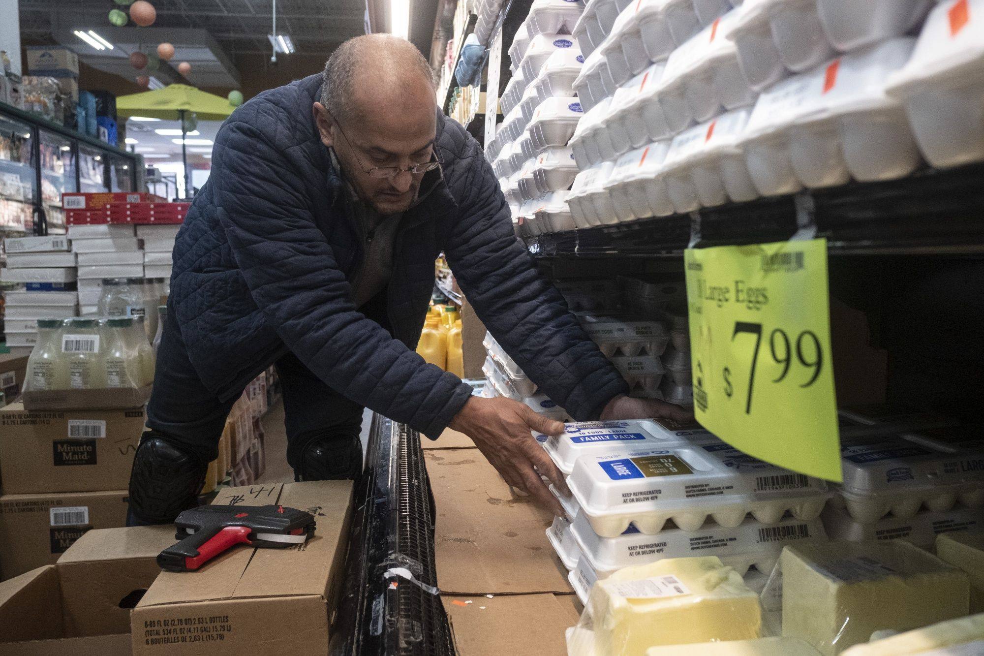 A worker stocks eggs on a shelf at a grocery store in Detroit, Michigan, on January 18. While egg prices remain stubbornly high, other price rises are easing, a sign that inflation may have peaked. Photo: Bloomberg