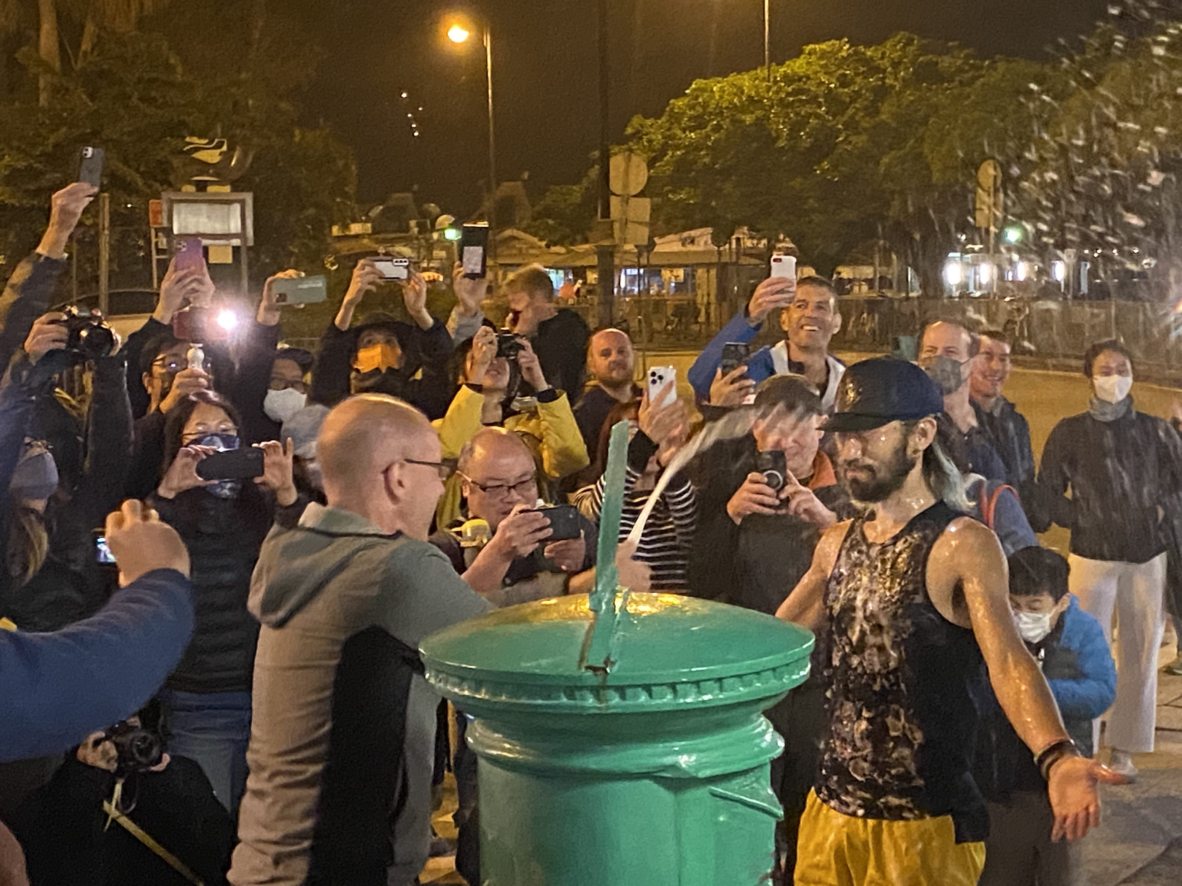 Tomokazu Ihara is sprayed with champagne after arriving first at the green postbox in Mui Wo, the finishing point of the 298km Hong Kong Four Trails Ultra Challenge. Photo: Josephine Ma