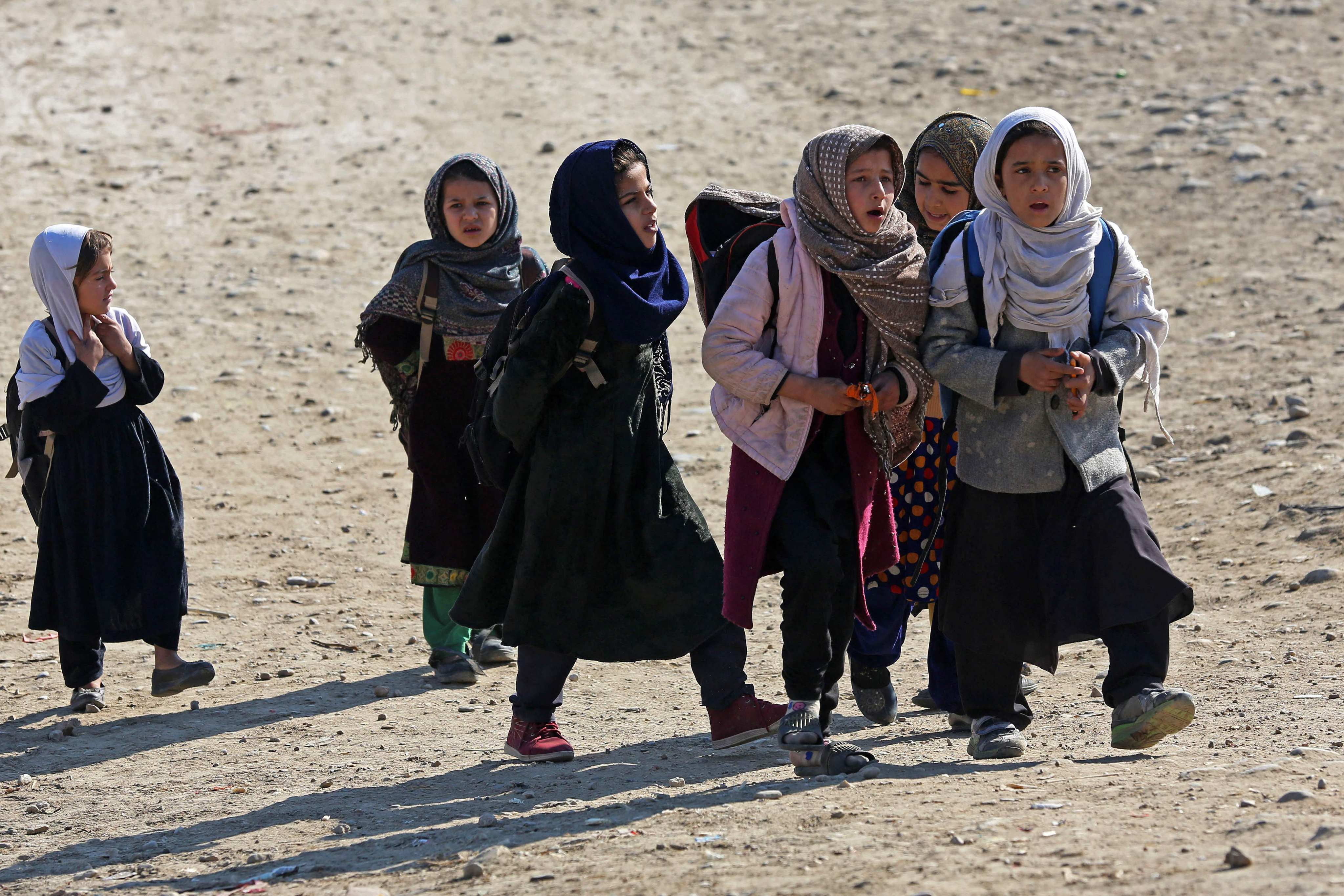 Afghan girls walk back to their homes after attending school in Jalalabad, on January 9. Incentives for families to send their daughters to school are among the many steps countries can take to improve education access and bolster economic growth. Photo: AFP
