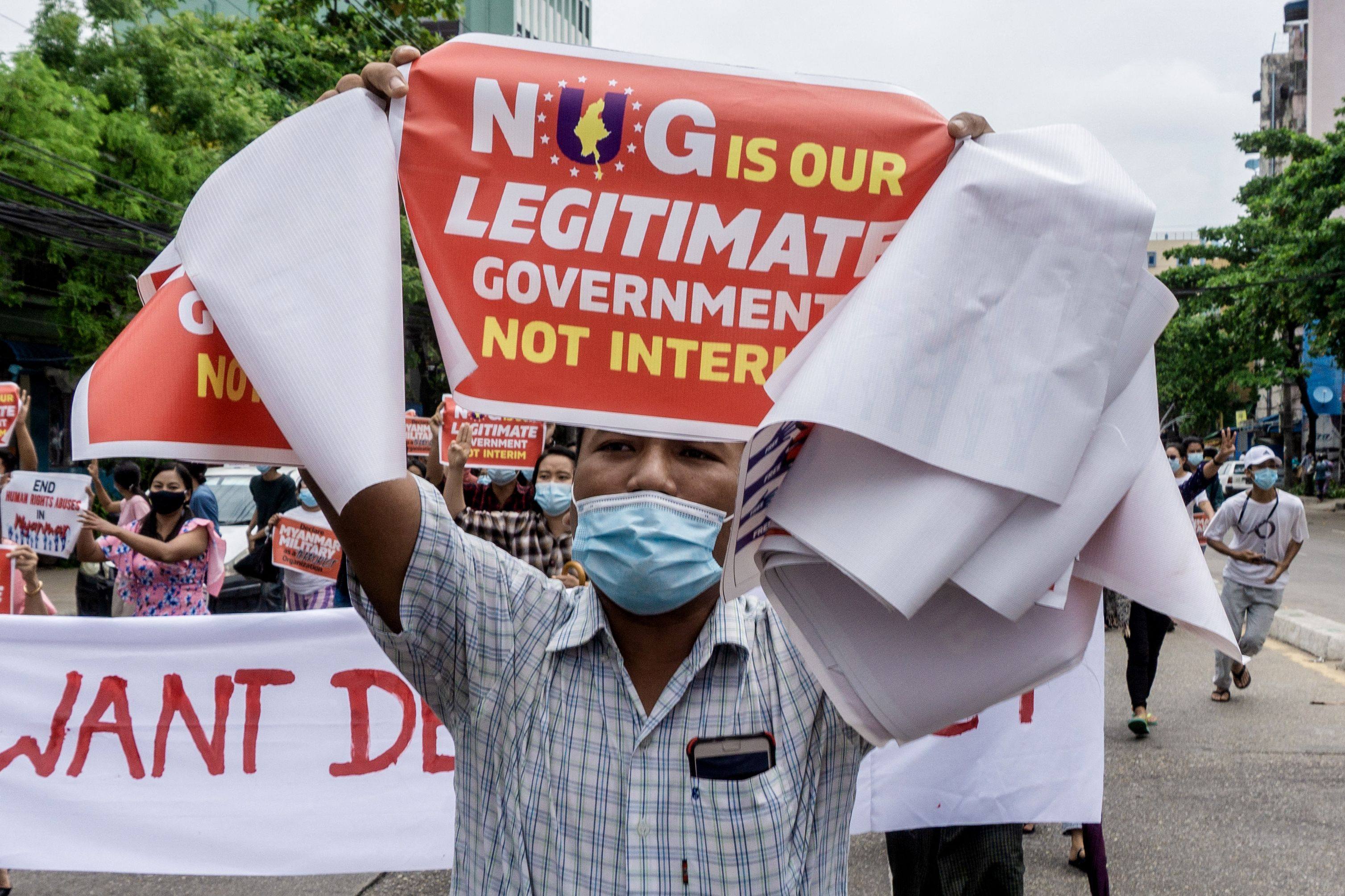 A protester carries a placard supporting the opposition National Unity Government (NUG) during a demonstration against the military coup in in Yangon. Photo: AFP/File
