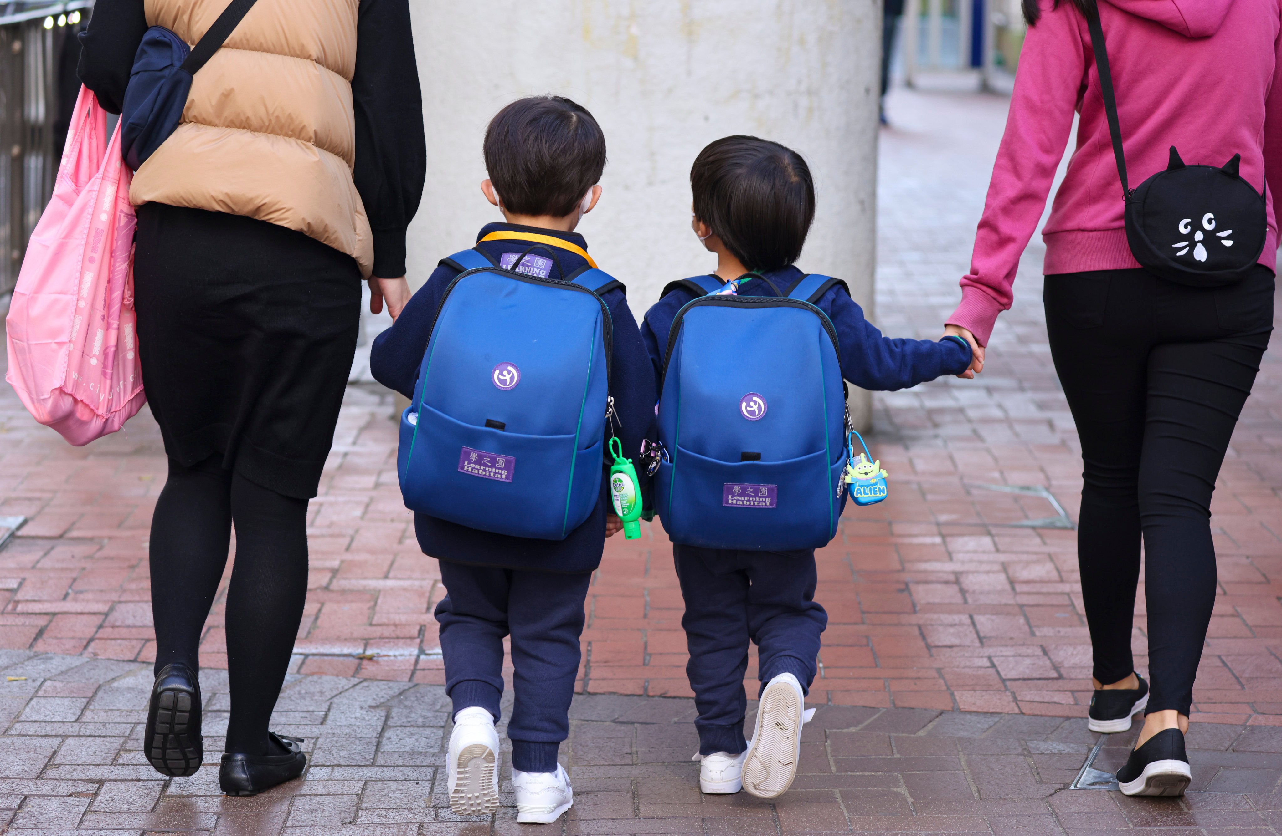 Children leave school in Quarry Bay on January 11, 2022. Some very young pupils have not known anything but face masks, Covid-19 tests, short school days and constant messaging about the dreaded virus. Photo: Nora Tam