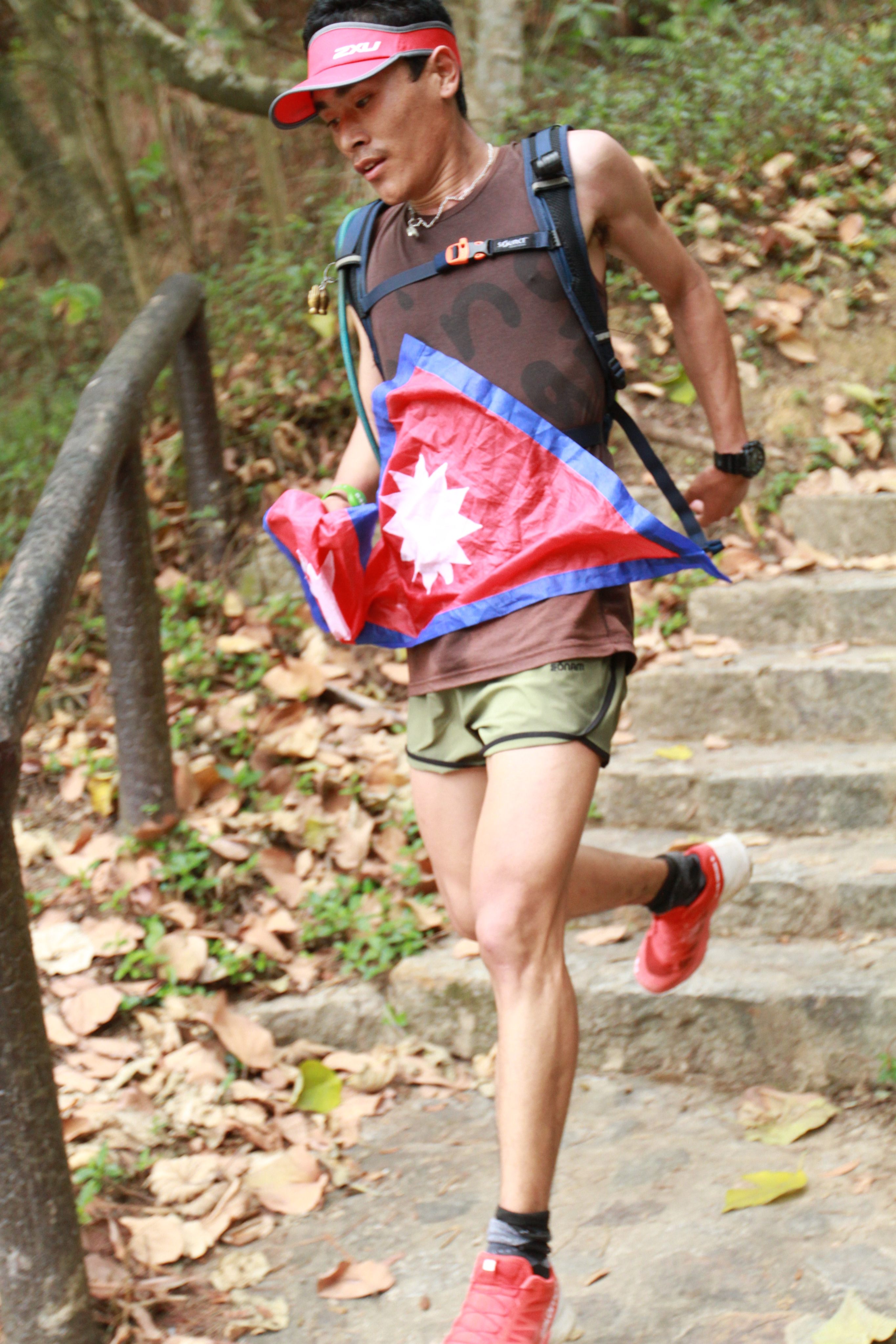 A runner displays the national flag of Nepal as he runs the Gurkha Trailblazer. Photo: Handout
