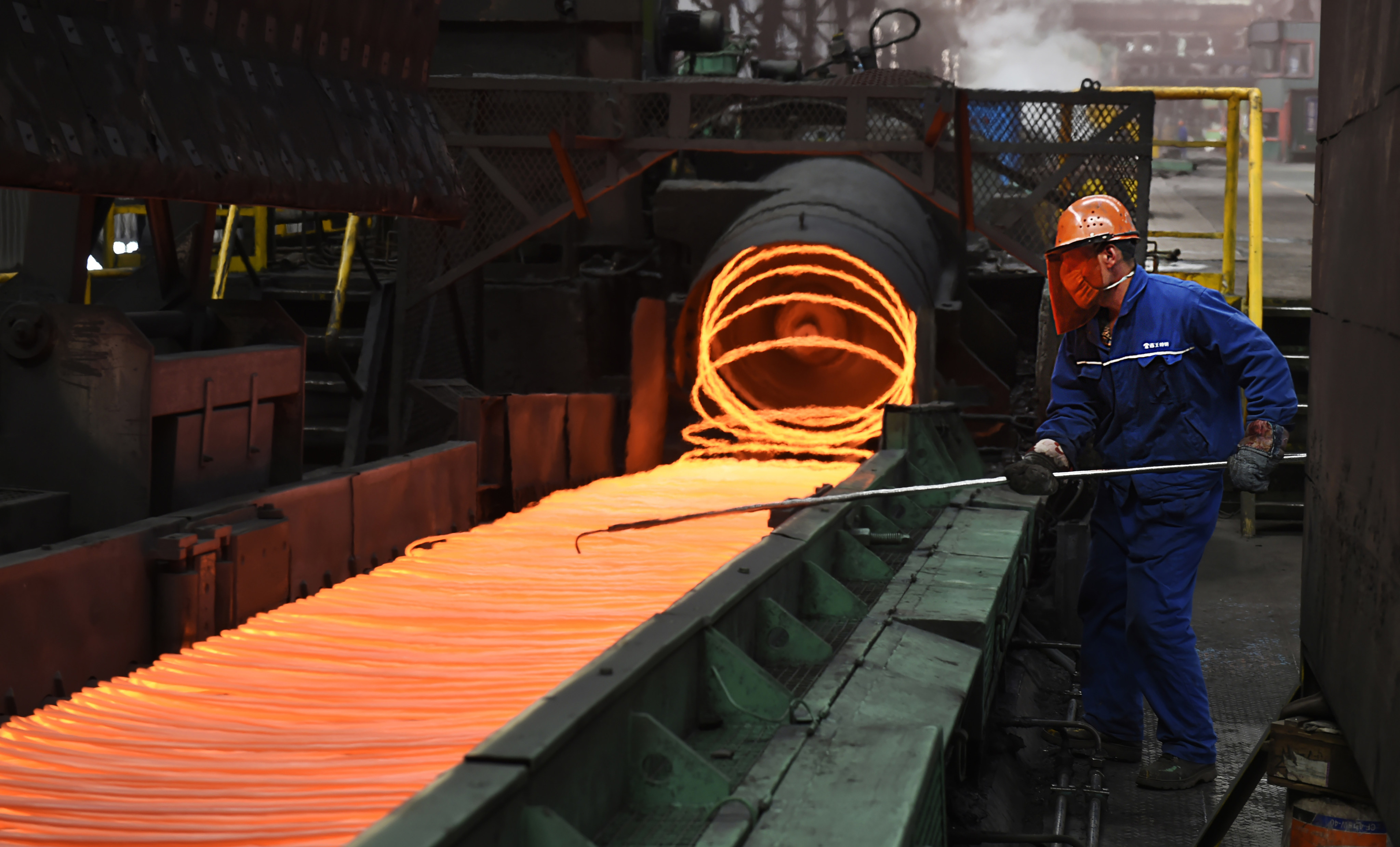 A worker manipulates coils of steel at Xiwang Special Steel in Zouping County in eastern China’s Shandong province. Photo: AP