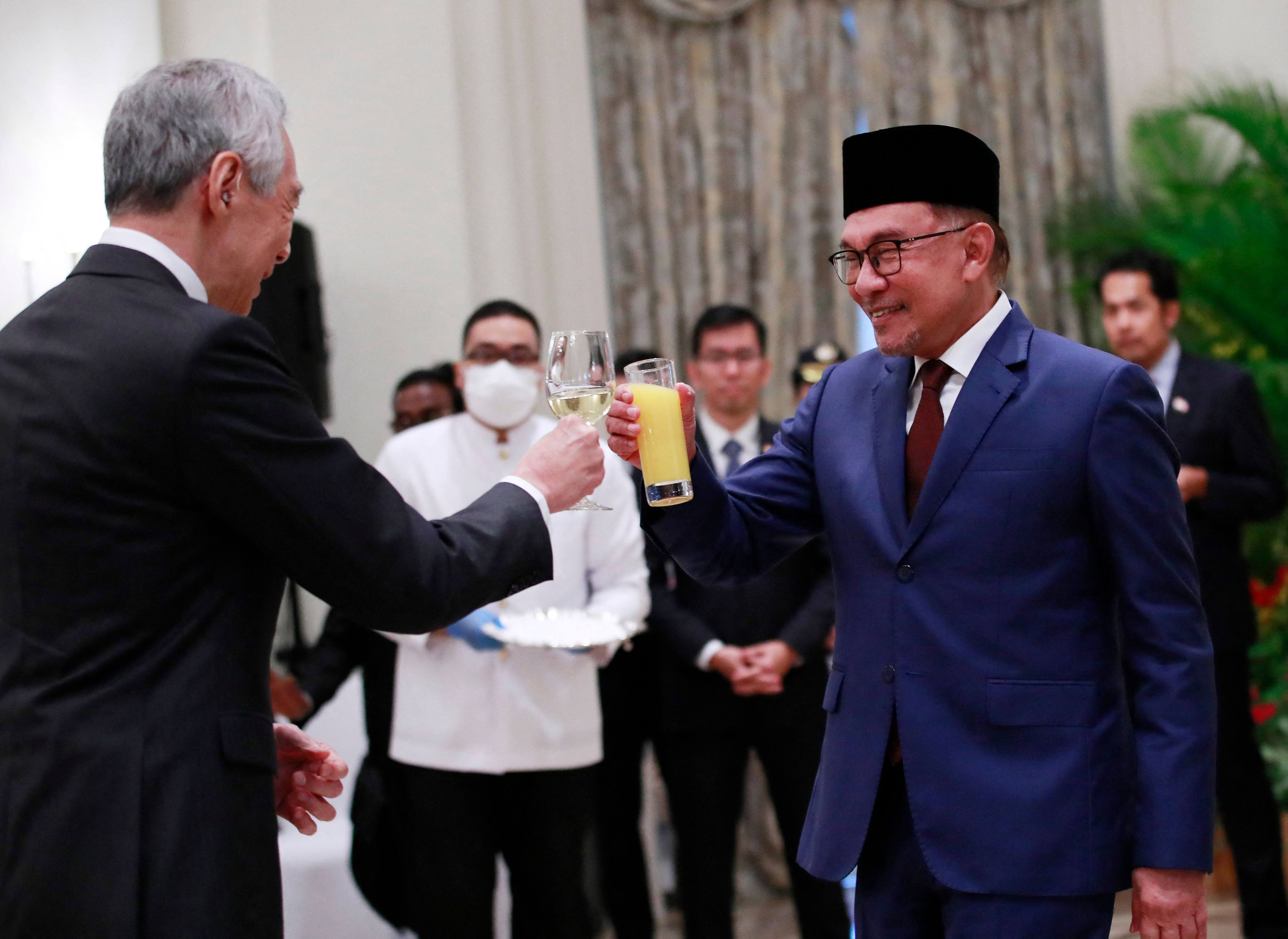 Malaysia’s PM Anwar Ibrahim (right) makes a toast with his Singaporean counterpart Lee Hsien Loong in Singapore on January 30. Photo: AFP 