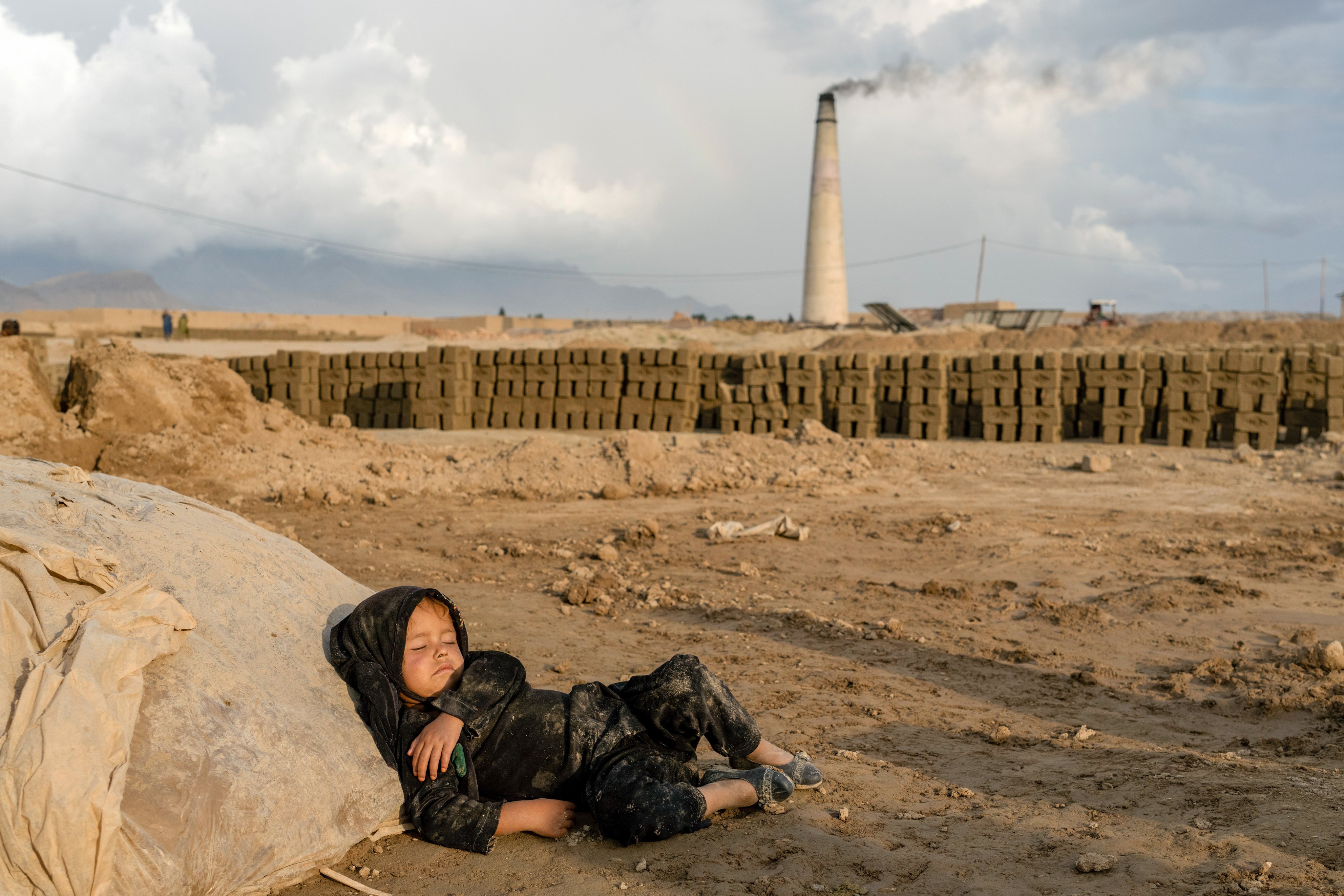 A four-year-old Afghan girl sleeps after work in a brick factory on the outskirts of Kabul on August 17. Aid agencies say more children are working since the economy collapsed after the Taliban takeover. Photo: AP