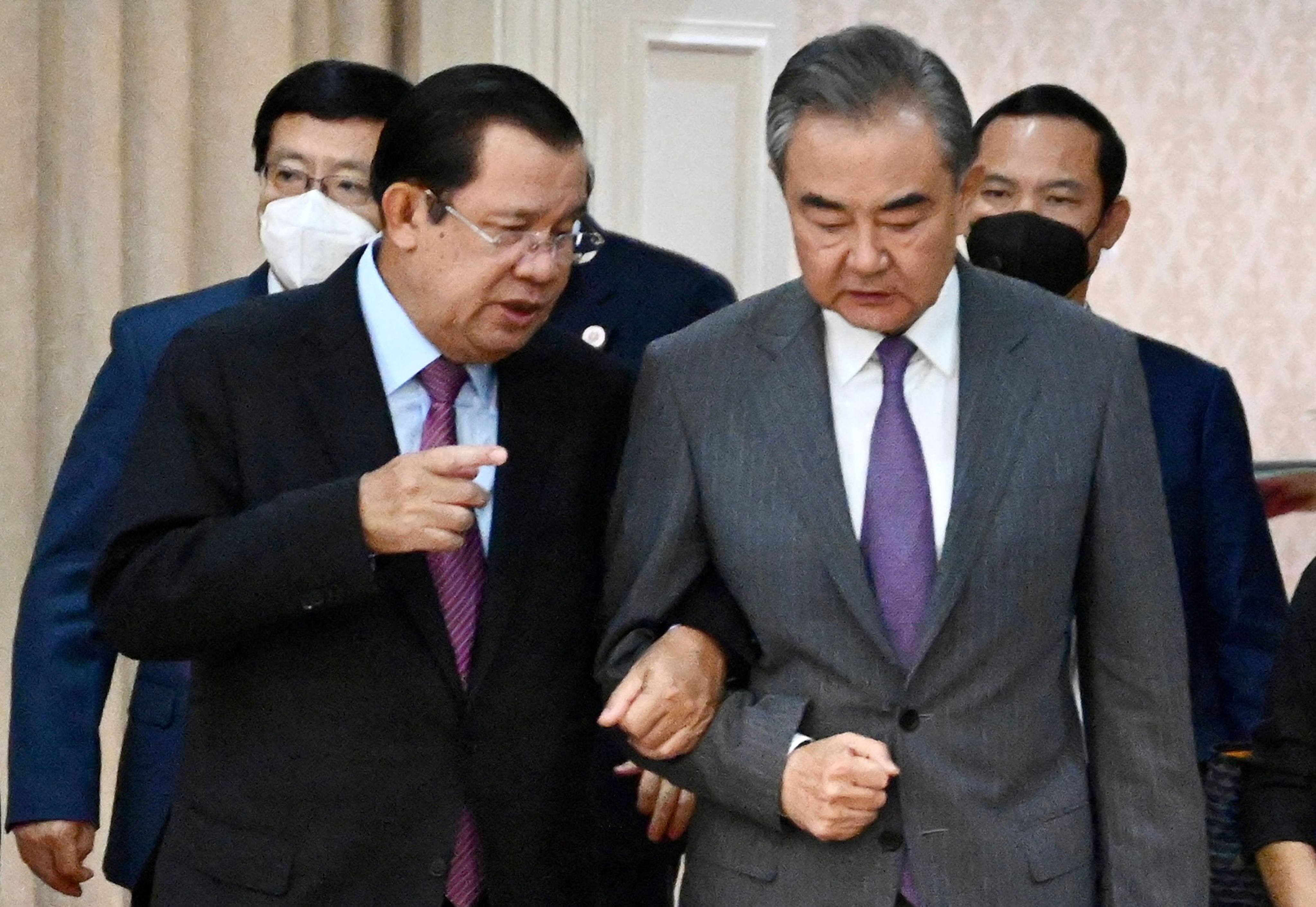 Cambodia’s Prime Minister Hun Sen (L) linking arms with China’s Foreign Minister Wang Yi (R) during a meeting at the Peace Palace in Phnom Penh in August 2022. Photo: Cambodia’s government cabinet/Handout via AFP/File