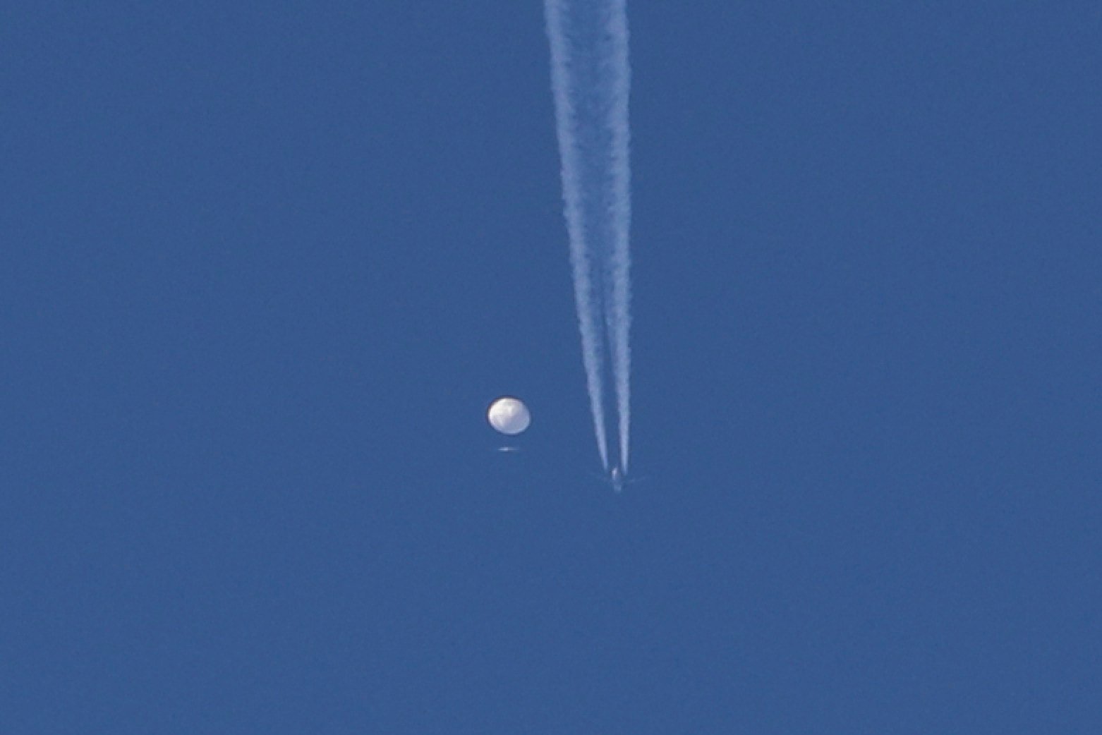 A large balloon drifts above the Kingstown, North Carolina, US area, with a plane and its contrail seen below it. The United States said it is a Chinese spy balloon. Photo: Brian Branch via AP