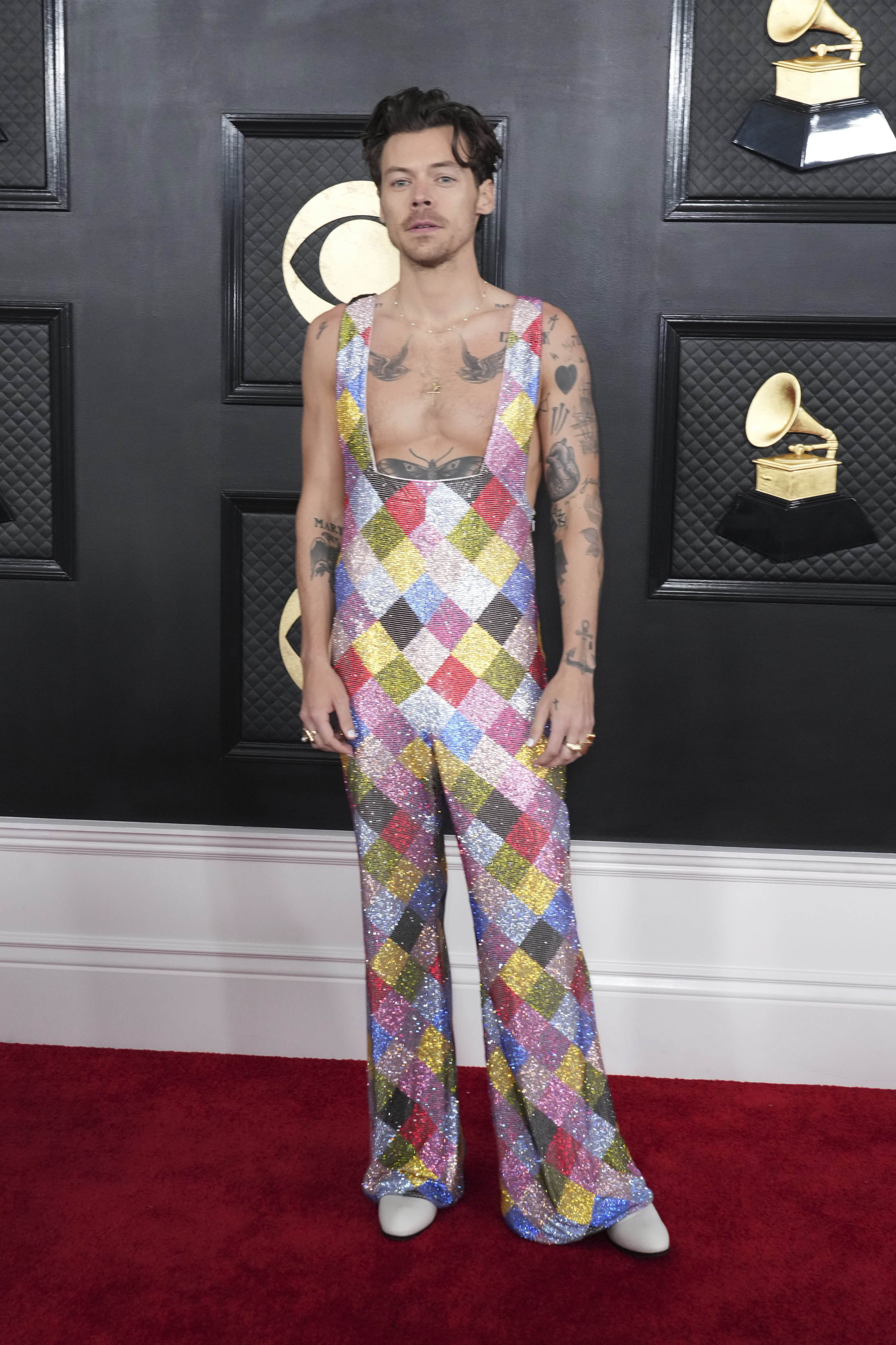 Harry Styles arrives for the Grammy Awards ceremony in a low-cut EgonLab jumpsuit. Photo: Jordan Strauss/Invision/AP
