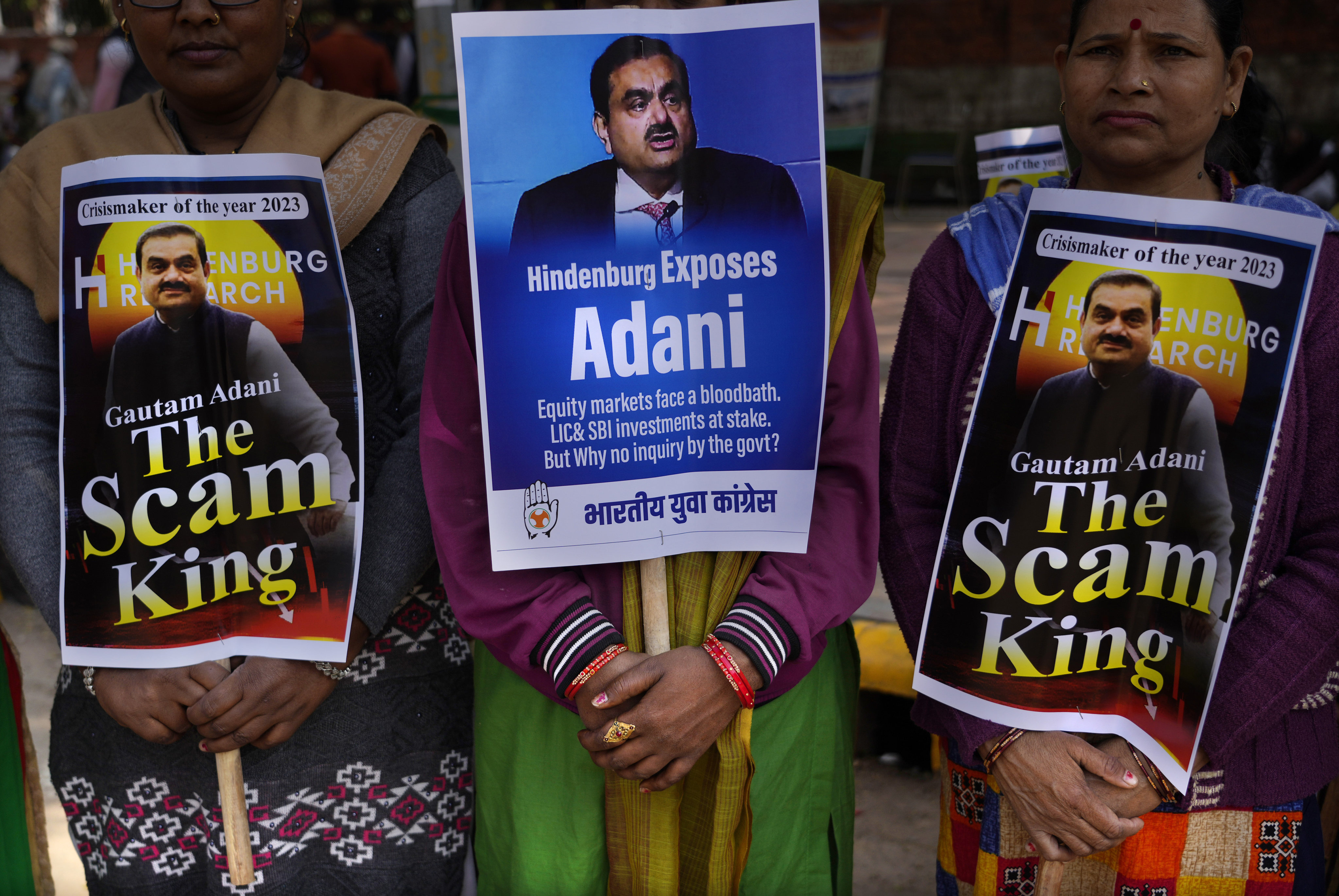 Congress party members hold placards with images of Indian businessman Gautam Adani during a protest in New Delhi on Monday. Photo: AP