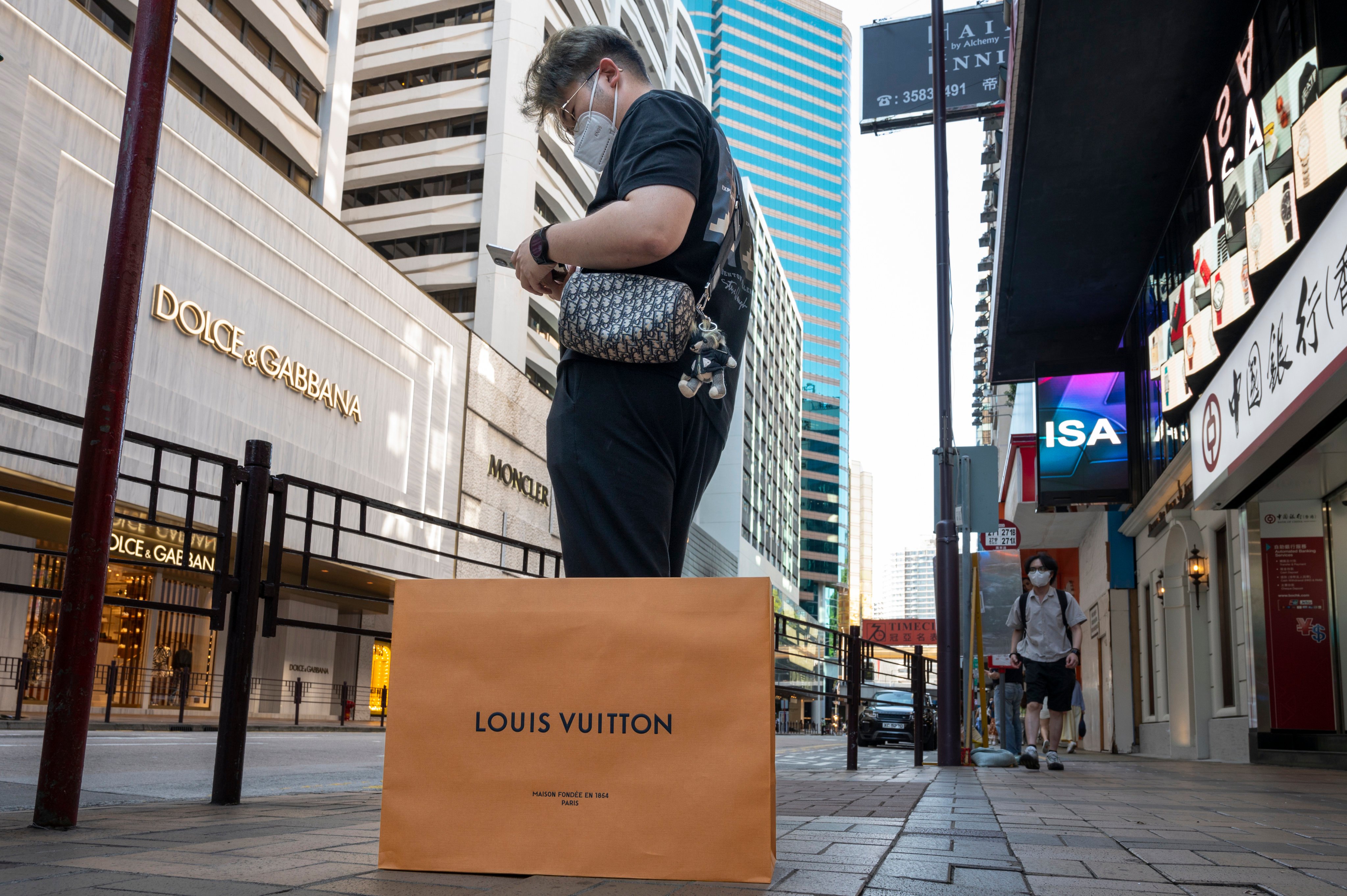 A luxury shopper stands opposite the Harbour City shopping mall in Tsim Sha Tsui, Hong Kong. Luxury sales in the city are predicted to rebound slowly in 2023. Photo: Getty Images