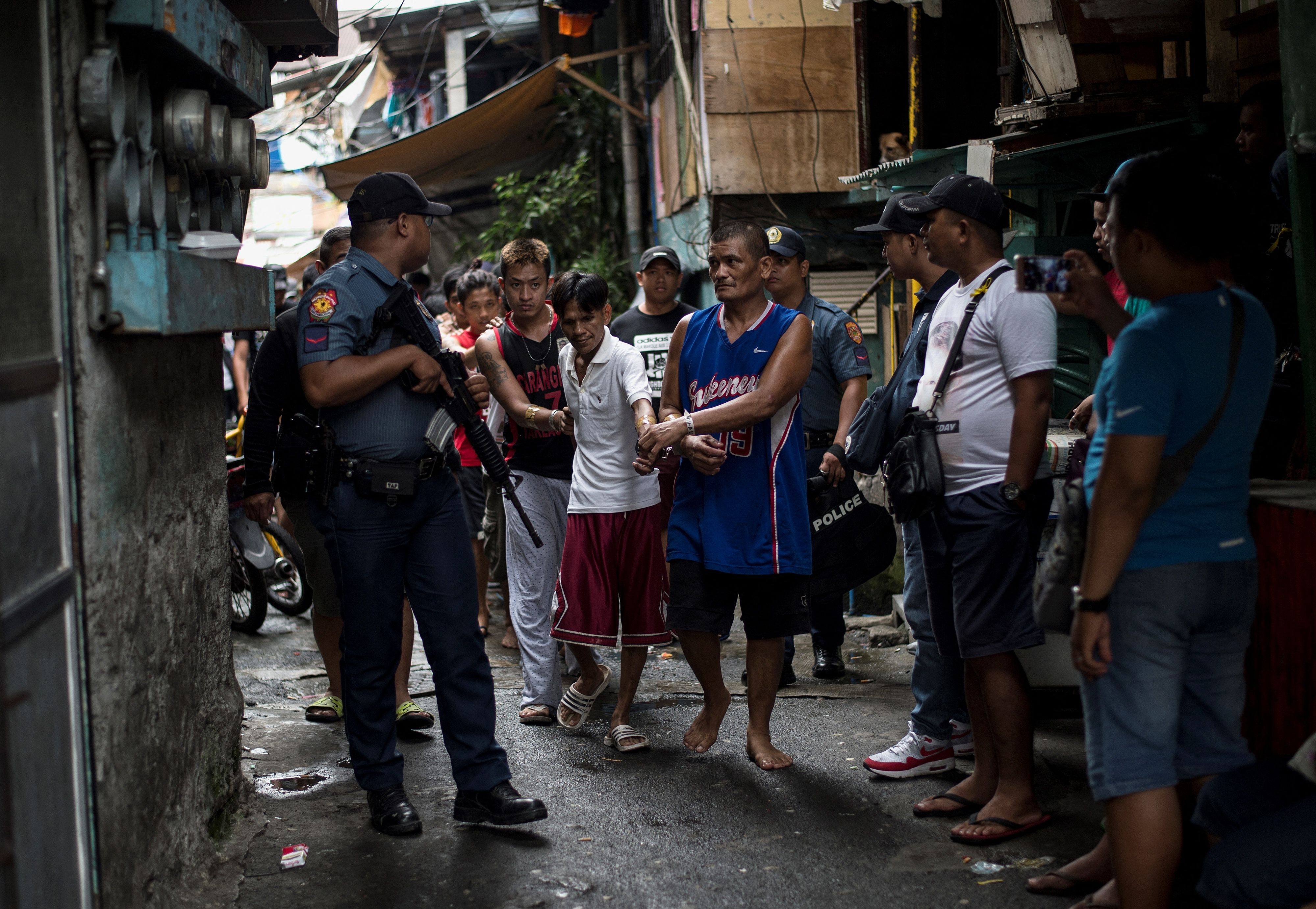Men are rounded up after police officers conduct a large-scale anti-drug raid at a slum community in Manila on July 20, 2017. Photo: AFP