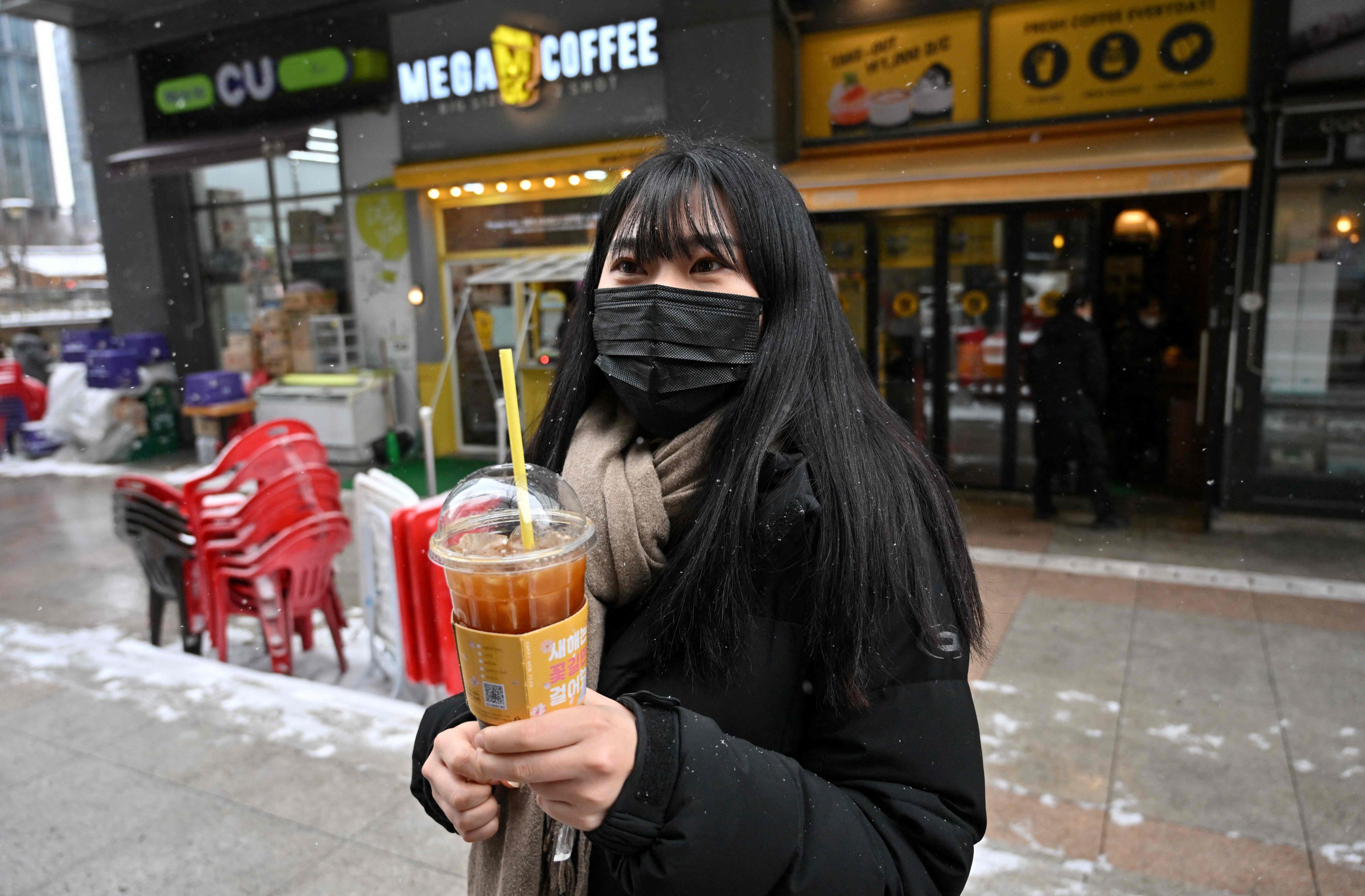 Office worker Lee Ju-eun holding an iced Americano in Seoul, South Korea. Photo: AFP