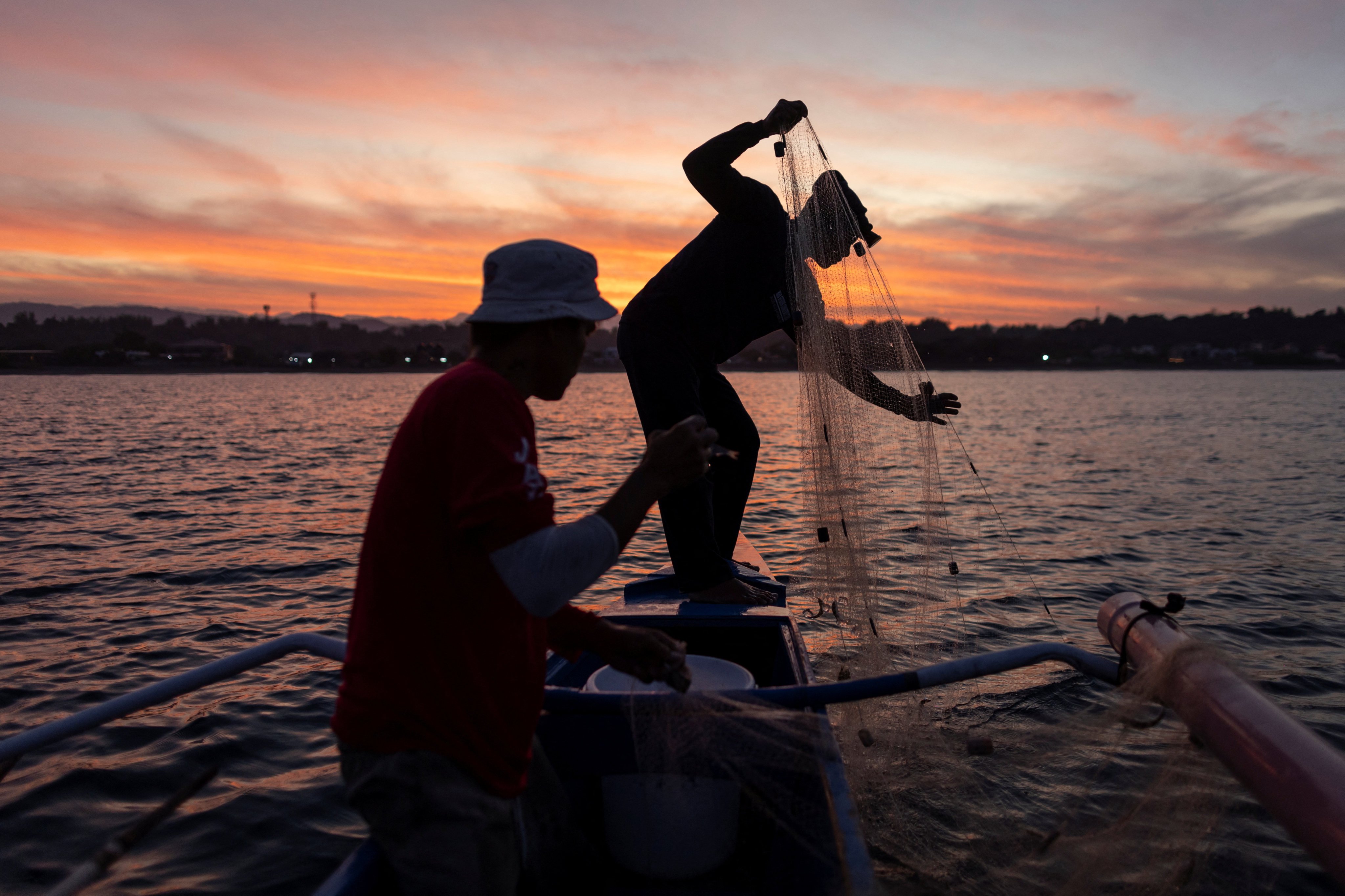 Men haul their fishing net on a boat in Bacnotan, La Union, Philippines. Protection of the environment depends on humans seeing past their own interests and working together. Photo: Reuters