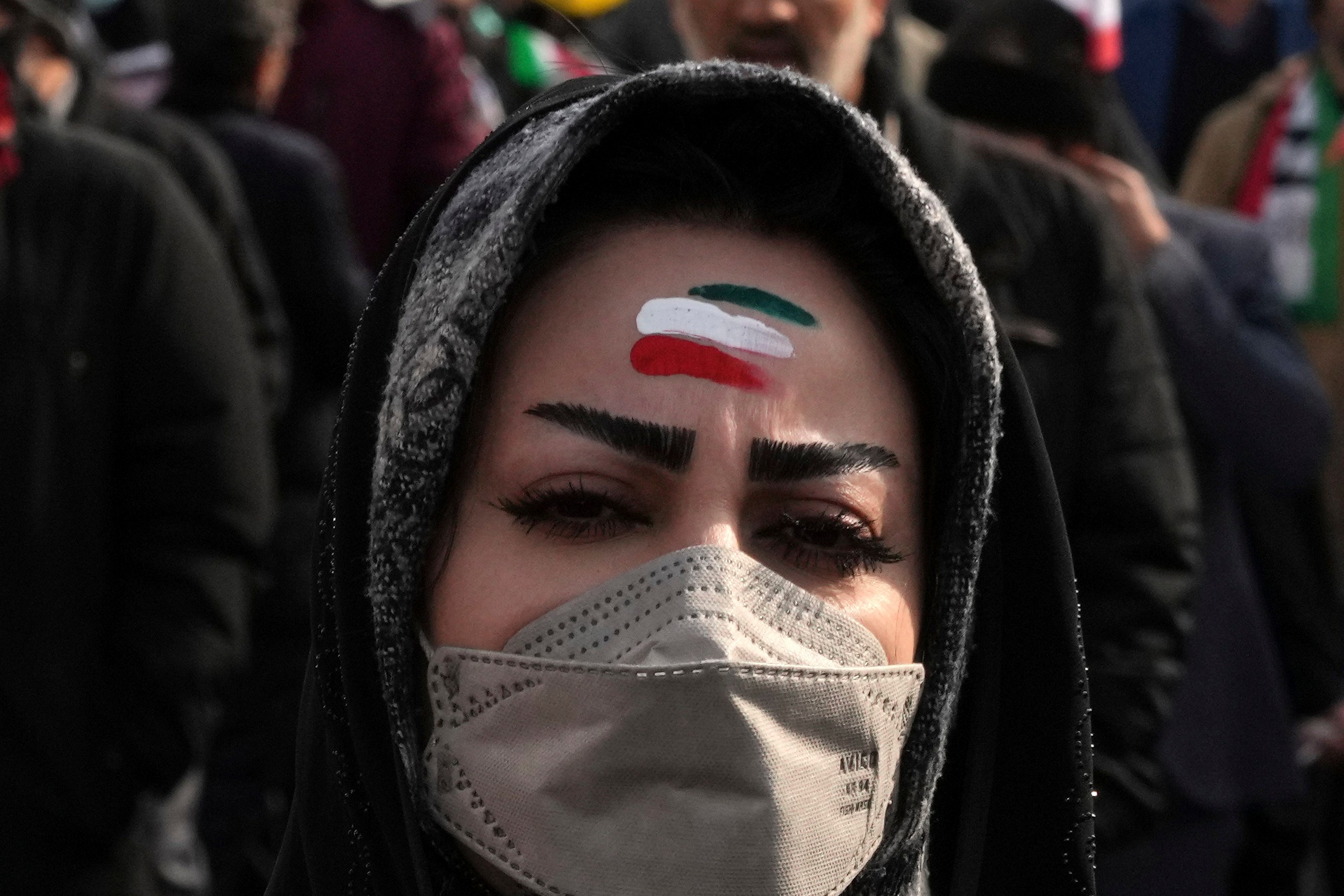 A woman with forehead painted with the Iranian flag’s colors takes part in the annual rally commemorating Iran’s 1979 Islamic Revolution, in Tehran, Iran. Photo: AP