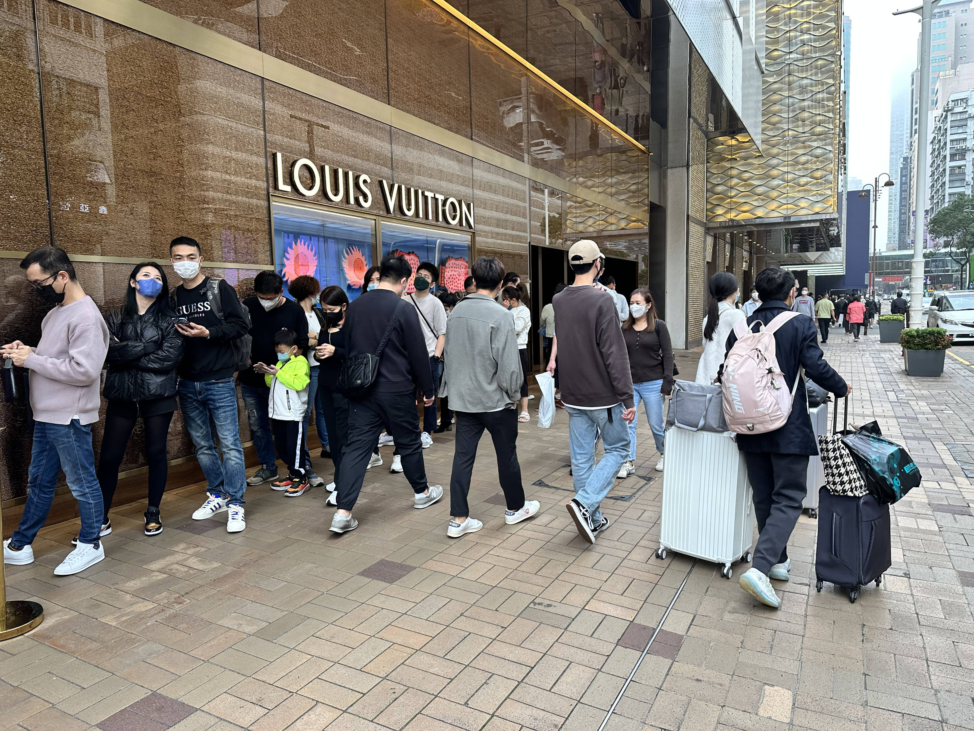 Shoppers queue outside luxury goods store Louis Vuitton in Tsim Sha Tsui on Sunday. Photo: Oscar Liu