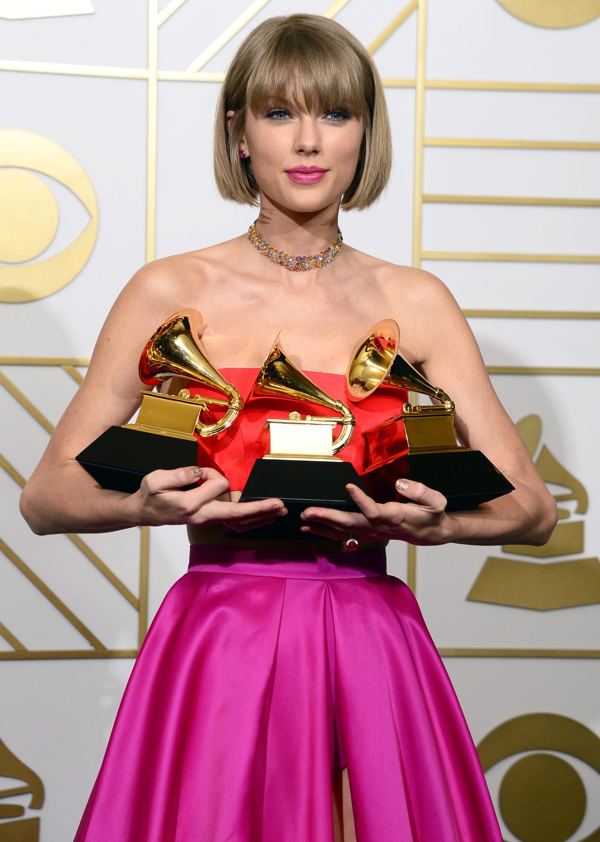 Taylor Swift holds up her awards for best music video, best pop vocal album and album of the year at the Grammy Awards in 2016. Photo: EPA