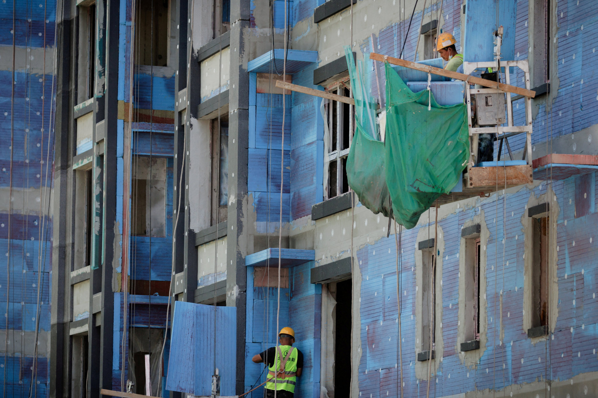 Men work at a construction site for apartment buildings in Beijing in July 2022. Photo: Reuters